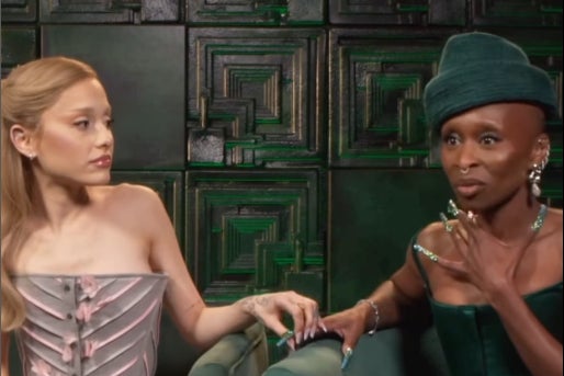 Ariana Grande sosteniendo el dedo de Cynthia Erivo