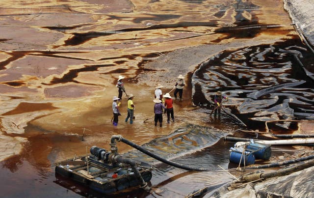 <p>Archivo. Trabajadores drenan el agua contaminada cerca de una mina en Shanghang</p>