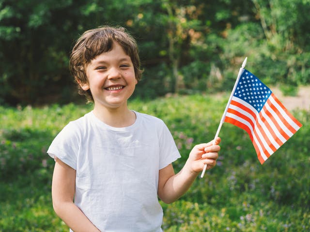 <p>Un niño estadounidense celebra el Día de la Independencia ondeando la bandera</p>