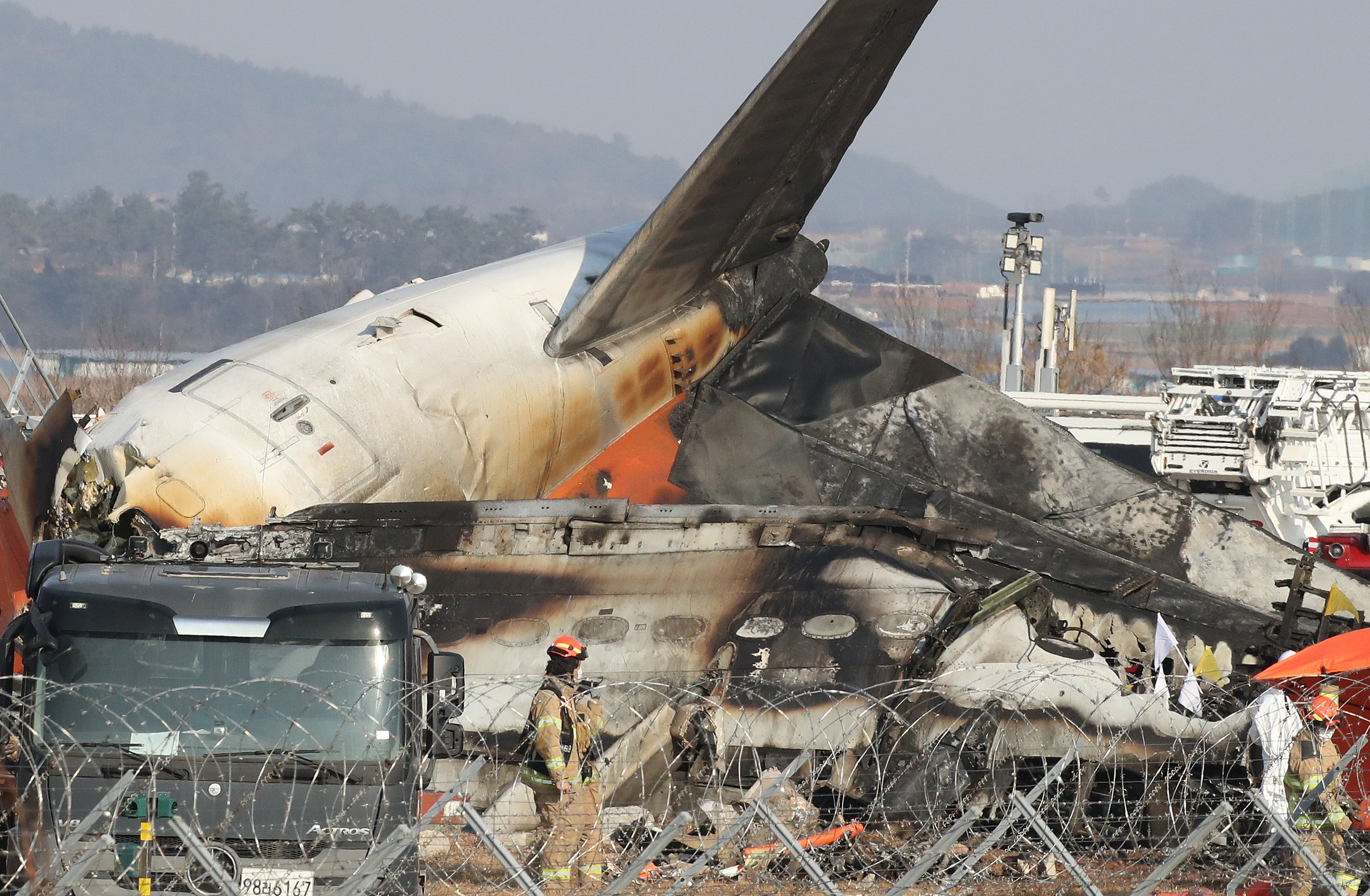 Los bomberos analizan los restos del avión en el aeropuerto internacional de Muan (Corea del Sur)