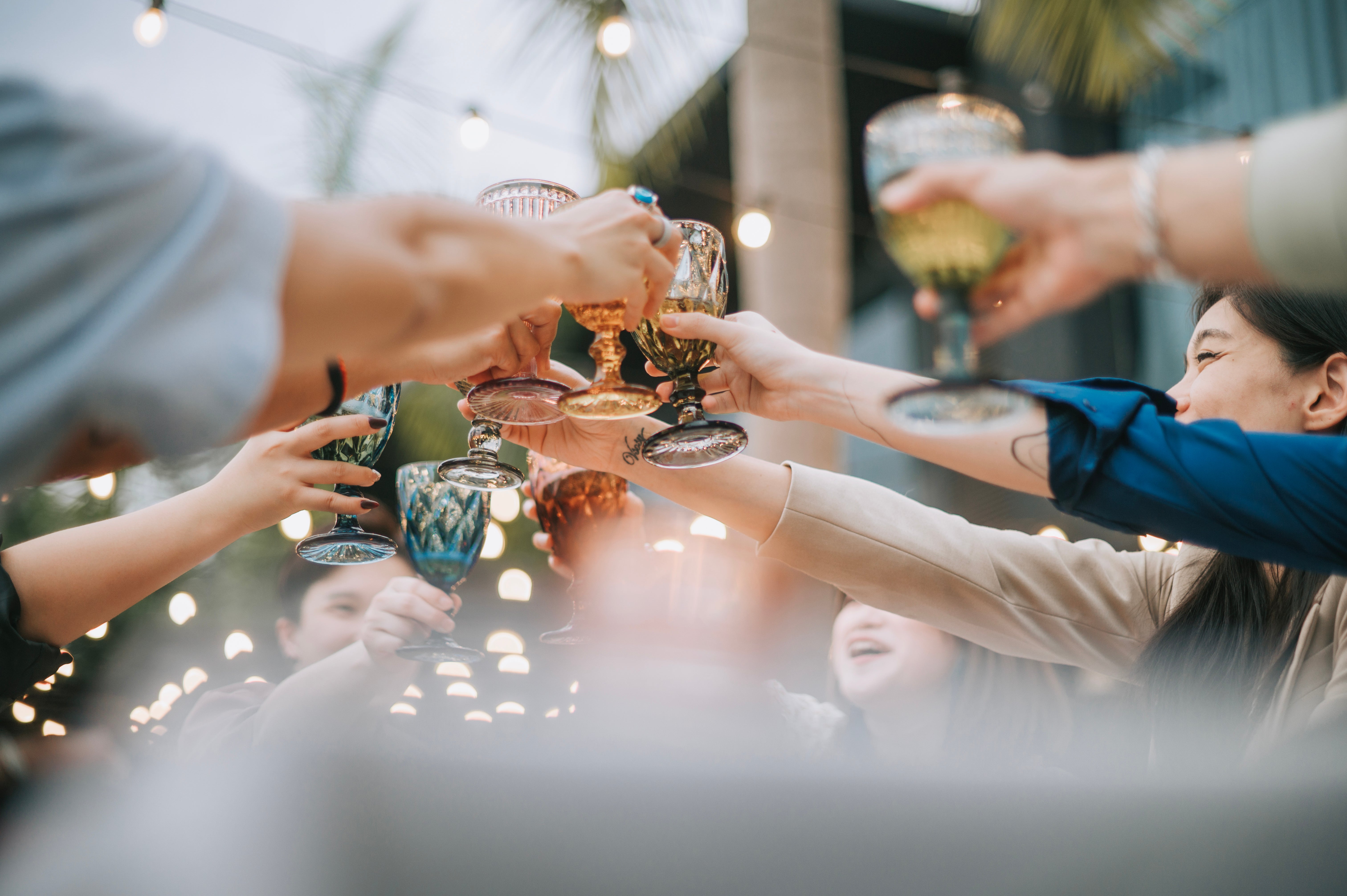 La gente celebra brindando con vasos de alcohol. En un informe reciente, el director general de Salud Pública de EE. UU. sugiere incluir etiquetas actualizadas que adviertan sobre los riesgos de cáncer asociados al consumo de alcohol