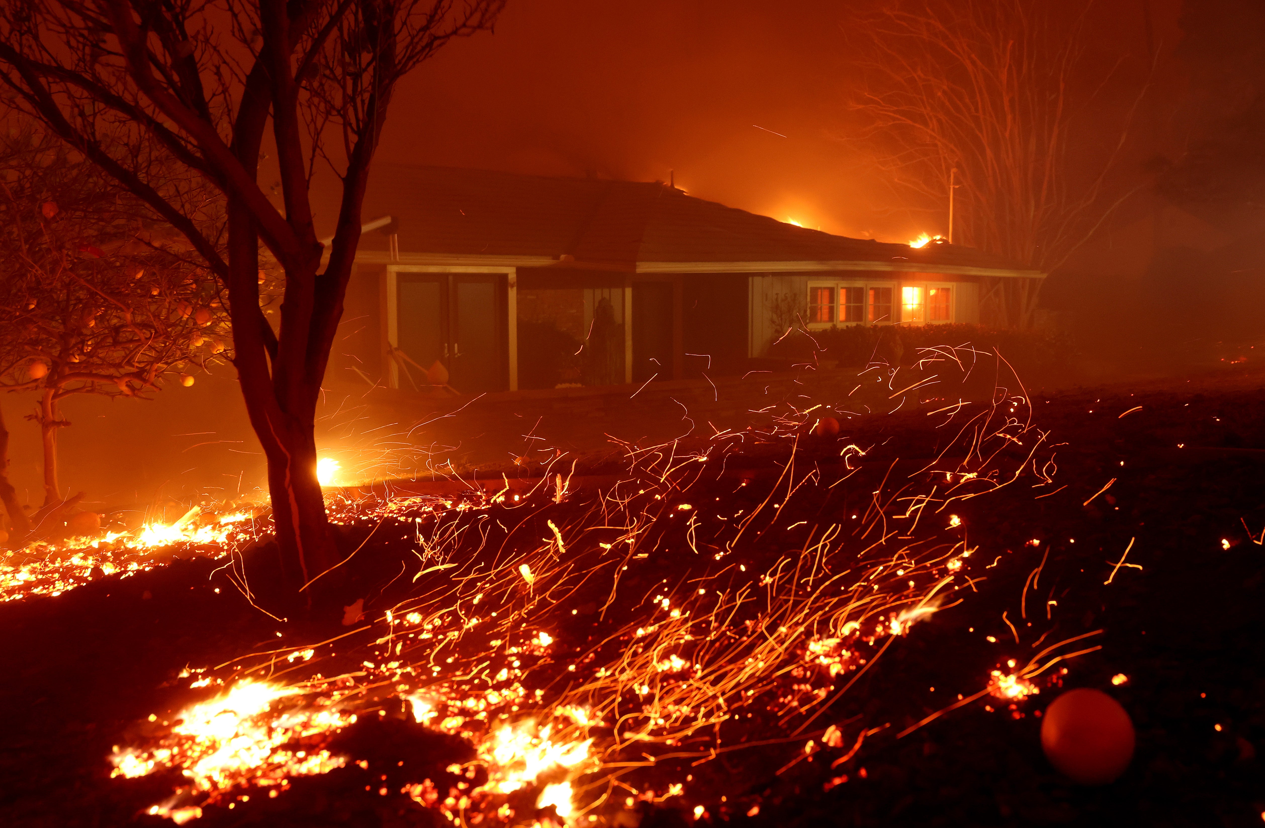 El viento empuja las brasas en una casa como el fuego Eaton se mueve a través de la zona el 8 de enero de 2025 en Altadena, California