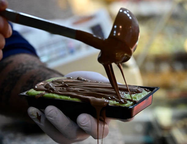 El comerciante Ali Fakhro prepara chocolate de Dubái en su pastelería oriental Abu Khaled Sweets, en Berlín, Alemania