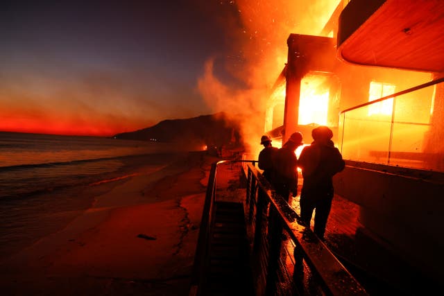 <p>Los bomberos trabajan desde una cubierta mientras el incendio Palisades quema una propiedad frente a la playa el miércoles 8 de enero de 2025, en Malibú, California</p>