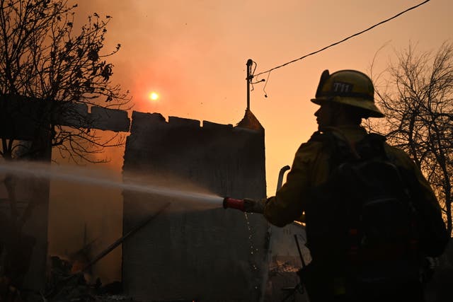 <p>Un bombero riega una casa tras el incendio Eaton en Altadena, California. Algunos se preguntan si el agua de mar puede utilizarse para apagar las llamas </p>