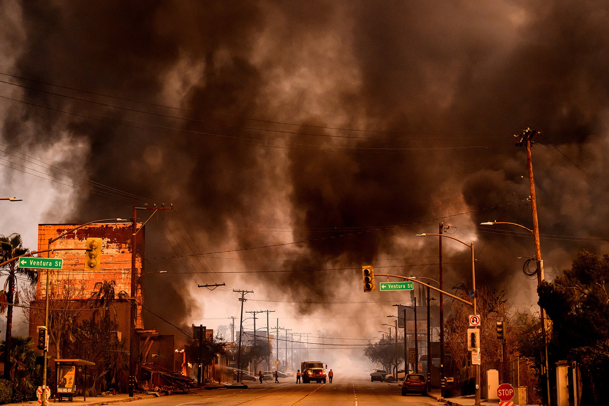 Humo y llamas sobrecogen una zona comercial durante el incendio de Eaton, en la zona de Altadena