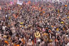 Ascetas hindúes desnudos y cubiertos en ceniza toman baño sagrado en festival Maha Kumbh