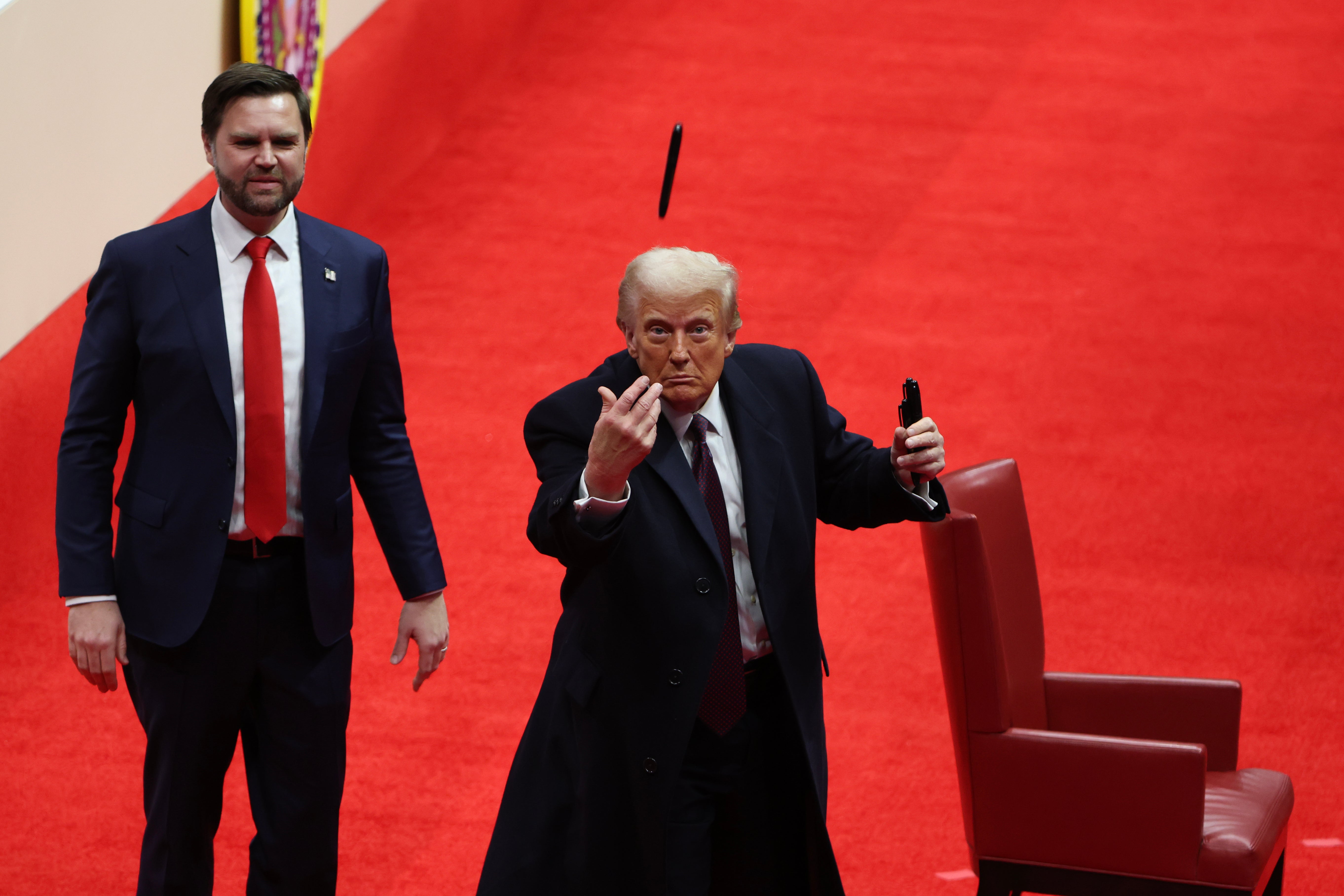 El vicepresidente J. D. Vance observa cómo el presidente Donald Trump lanza un bolígrafo después de firmar órdenes ejecutivas durante un desfile de inauguración en el Capital One Arena el 20 de enero de 2025 en Washington, D. C.