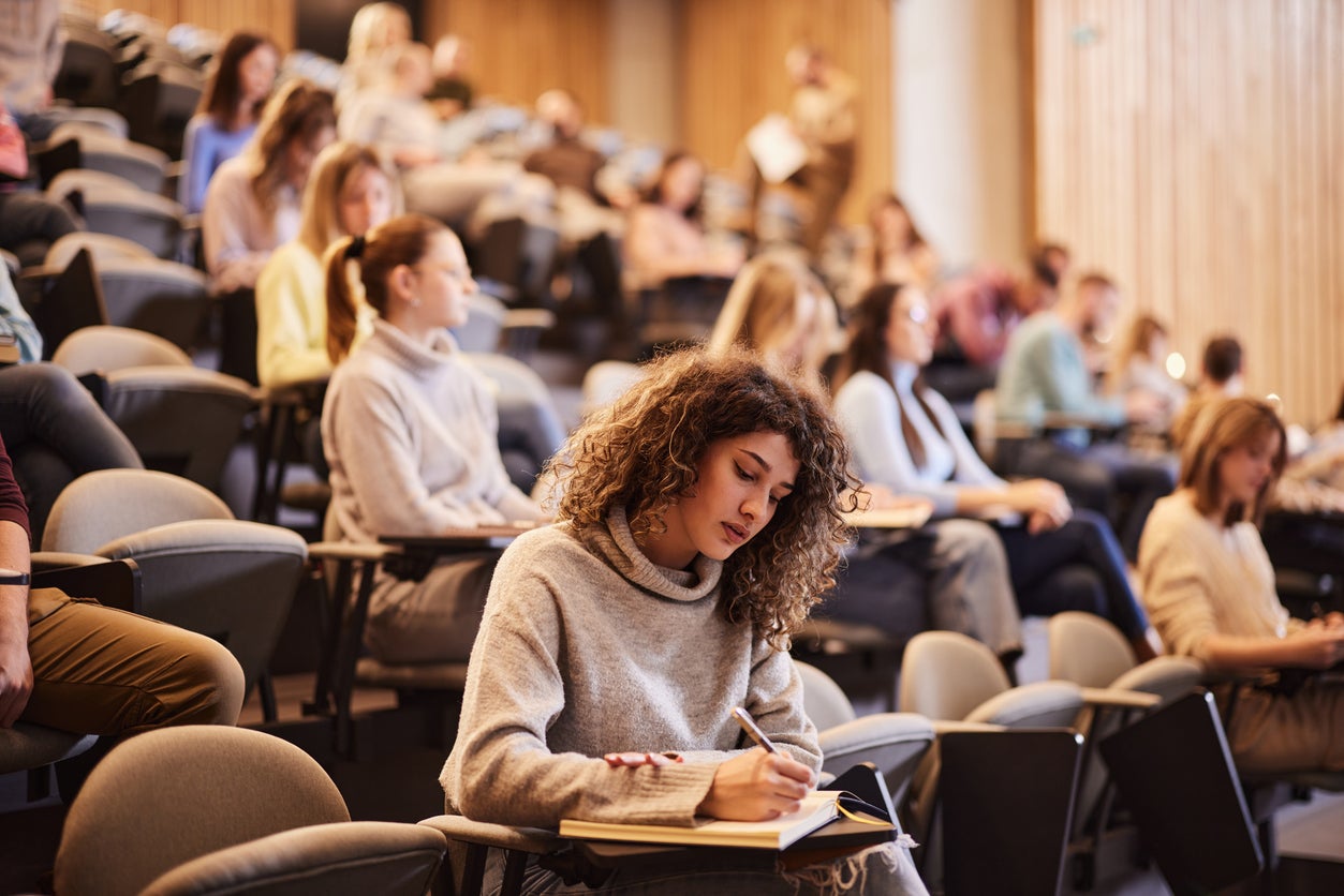 Estudiante universitaria escribiendo durante una clase