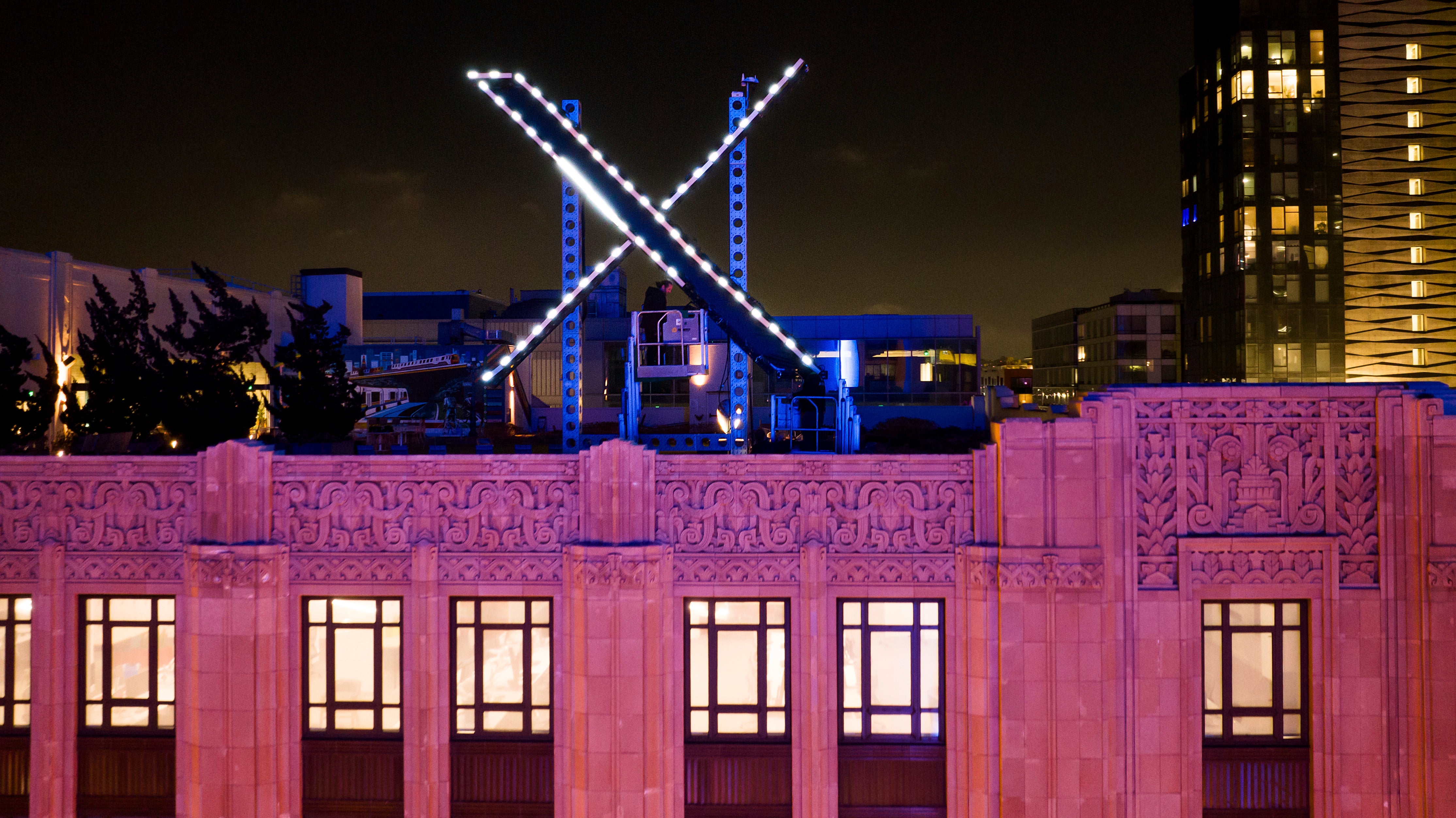 Trabajadores instalan la iluminación de una gigantesca "X" en la parte superior de la sede de la empresa, en el centro de San Francisco