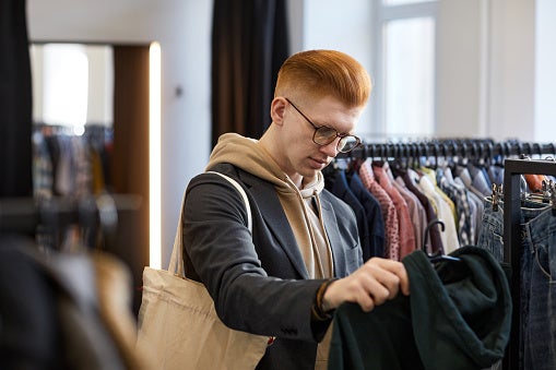 Un hombre mirando ropa de segunda mano
