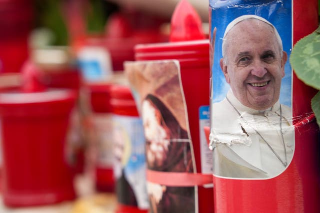 <p>Una vela con una foto del papa Francisco frente al hospital Gemelli de Roma, donde está siendo tratado de una bronquitis</p>