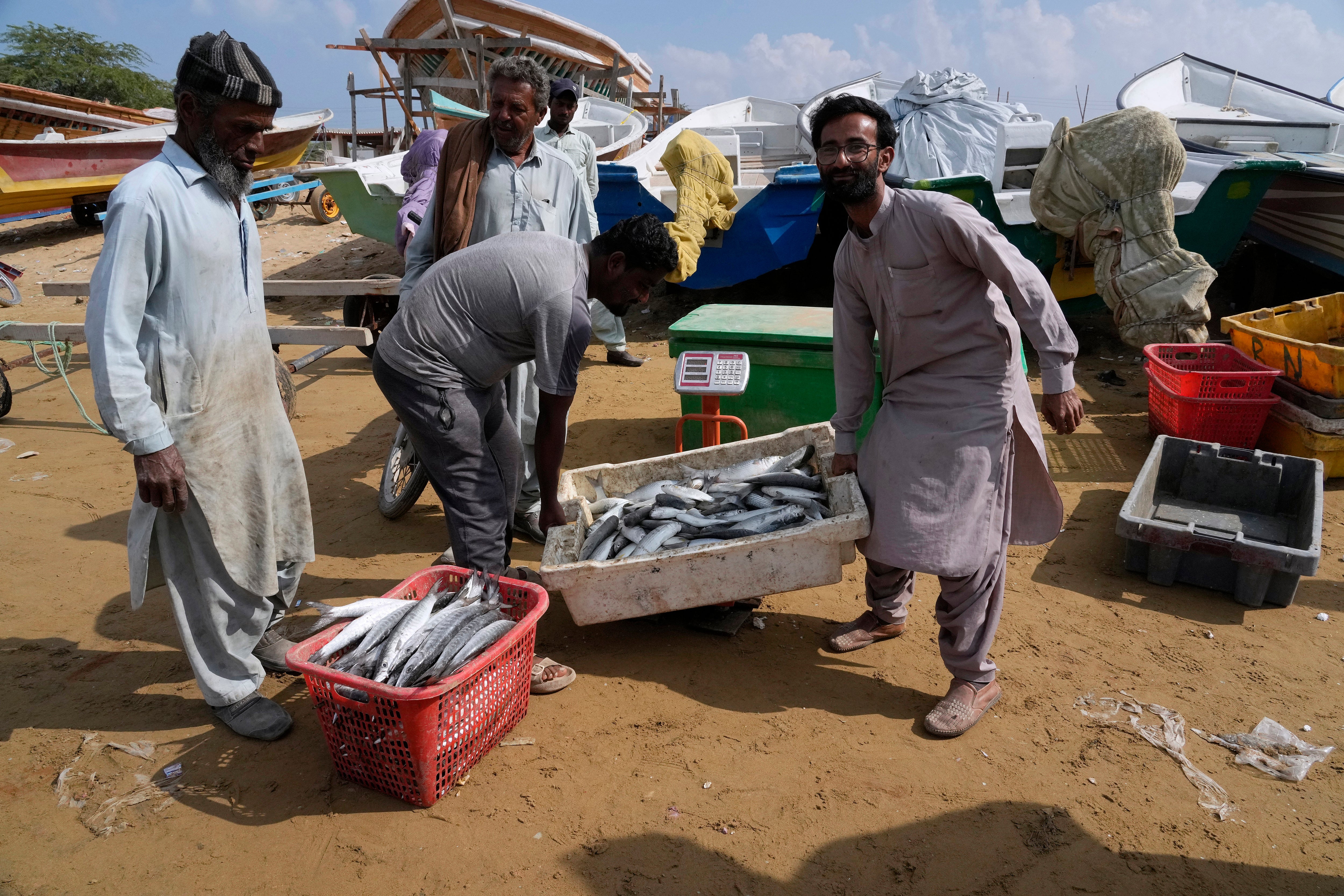 Pescadores pesan su captura en una báscula en la ciudad costera de Gwadar, en la provincia suroccidental de Baluchistán, Pakistán