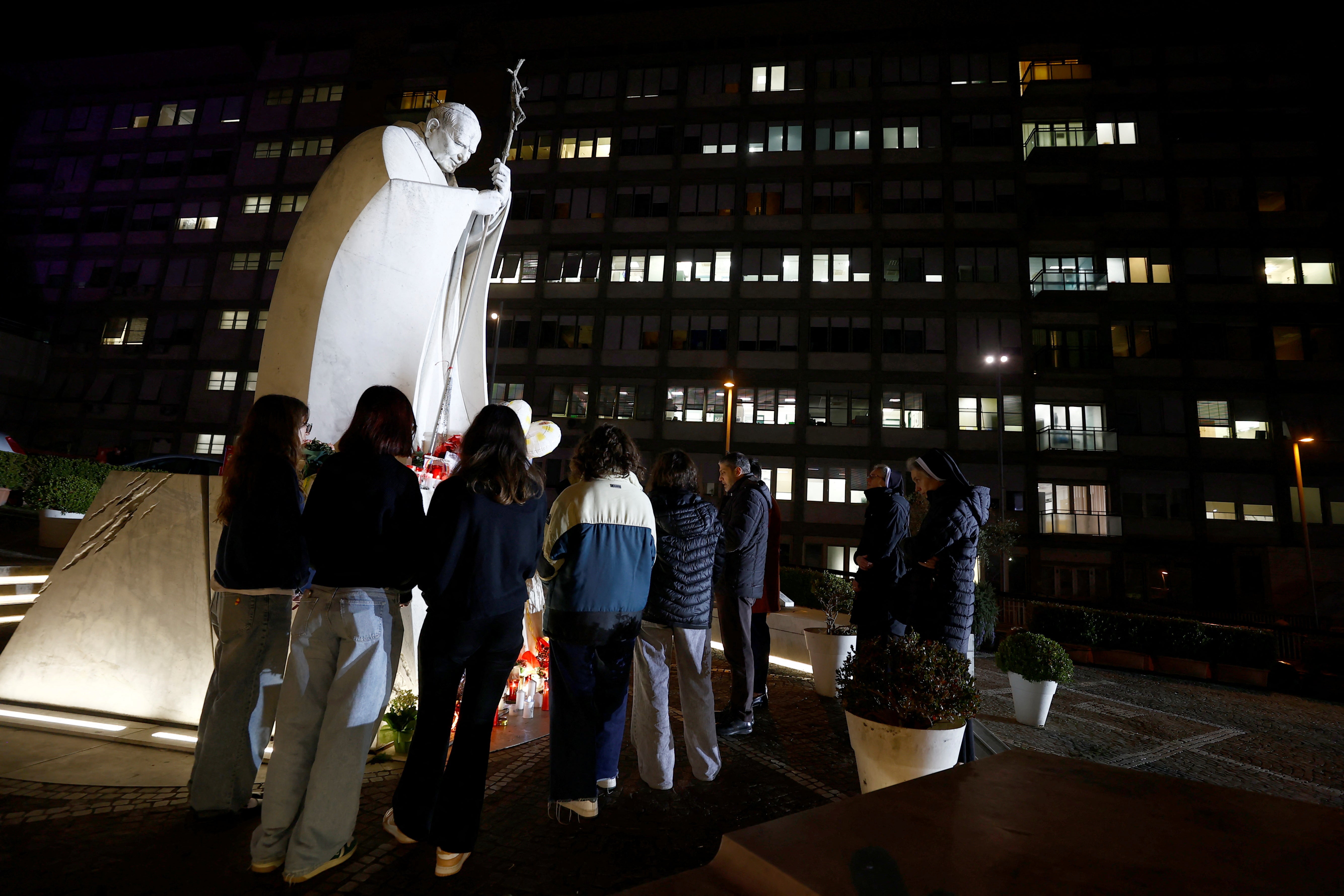 Varias personas rezan a las puertas del hospital Gemelli de Roma, donde se encuentra ingresado el Papa Francisco