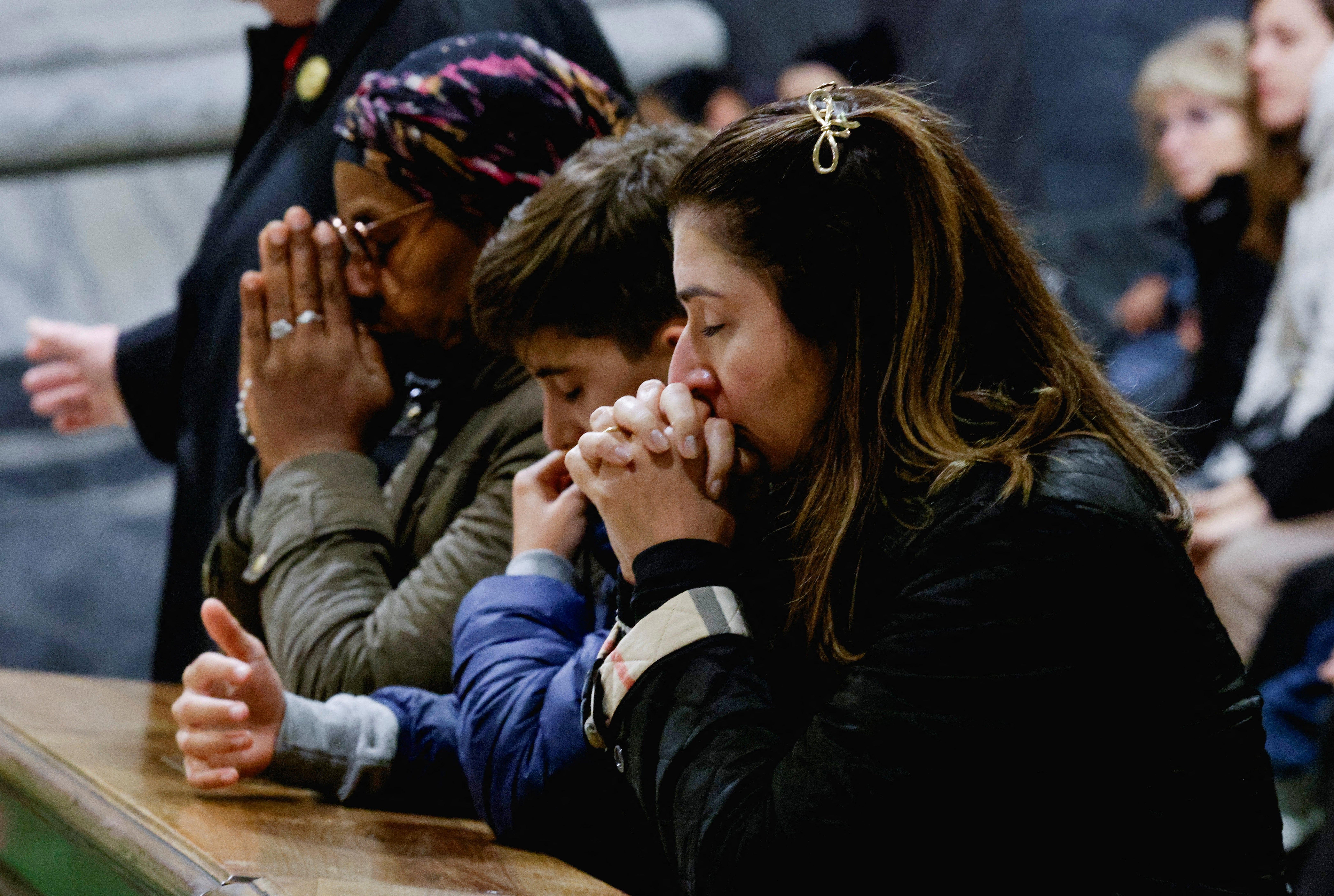 Un grupo de personas reza por el papa Francisco, que se encuentra en estado crítico tras una neumonía doble, en la Basílica de San Pedro del Vaticano el domingo