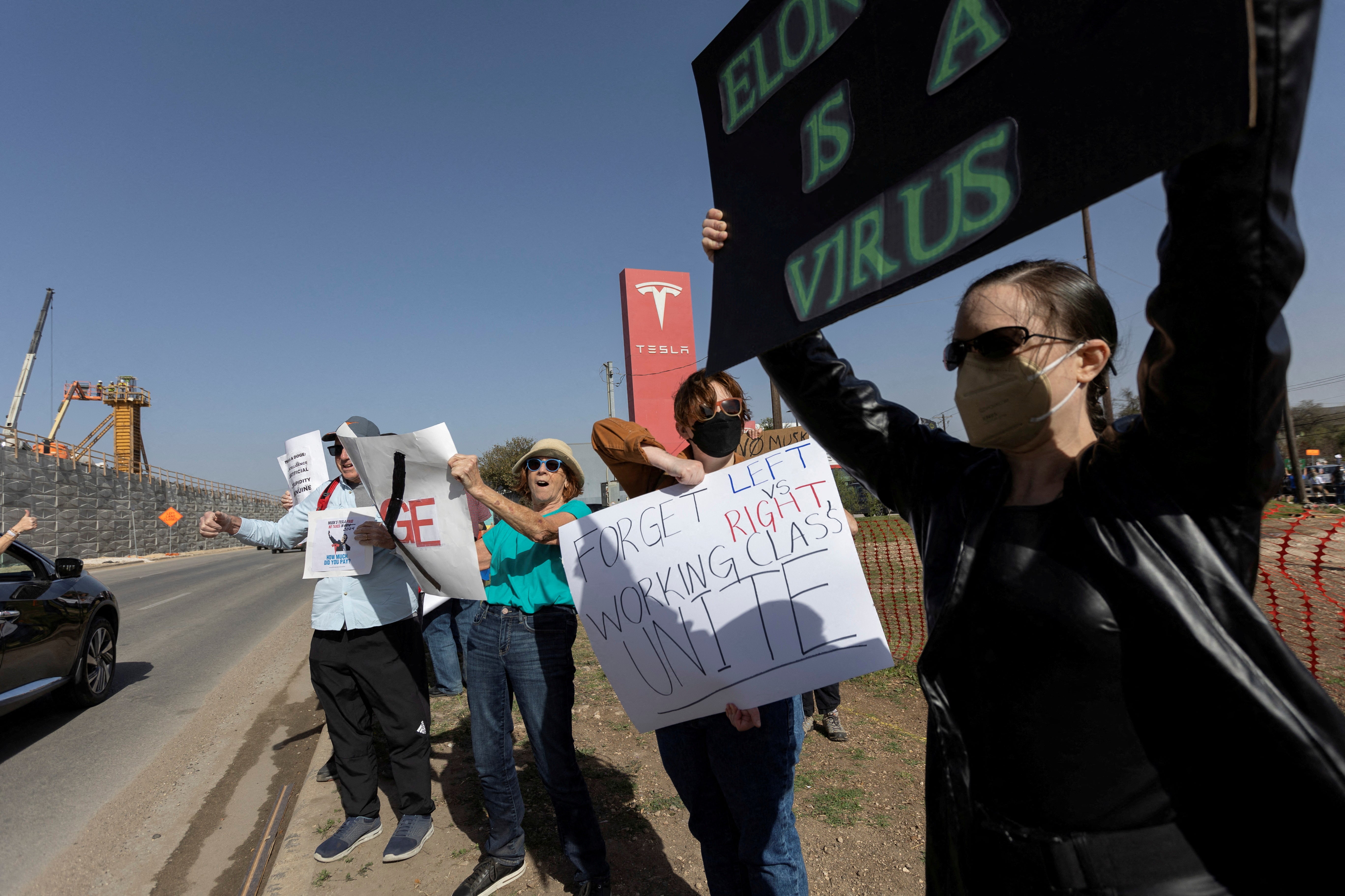 Manifestantes protestan contra Elon Musk frente a un concesionario de Tesla en Austin