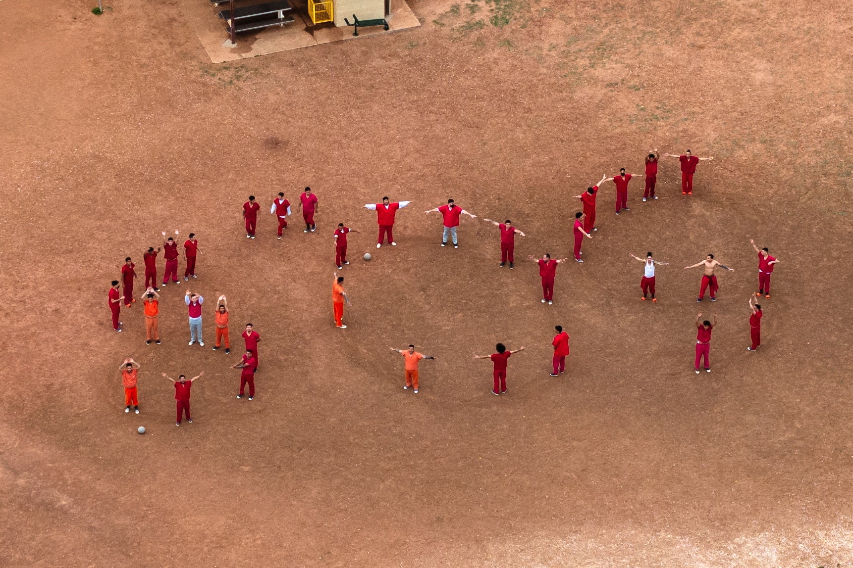 Detenidos venezolanos formando las letras “SOS” con sus cuerpos en el patio del centro de detención de Bluebonnet en Anson, Texas