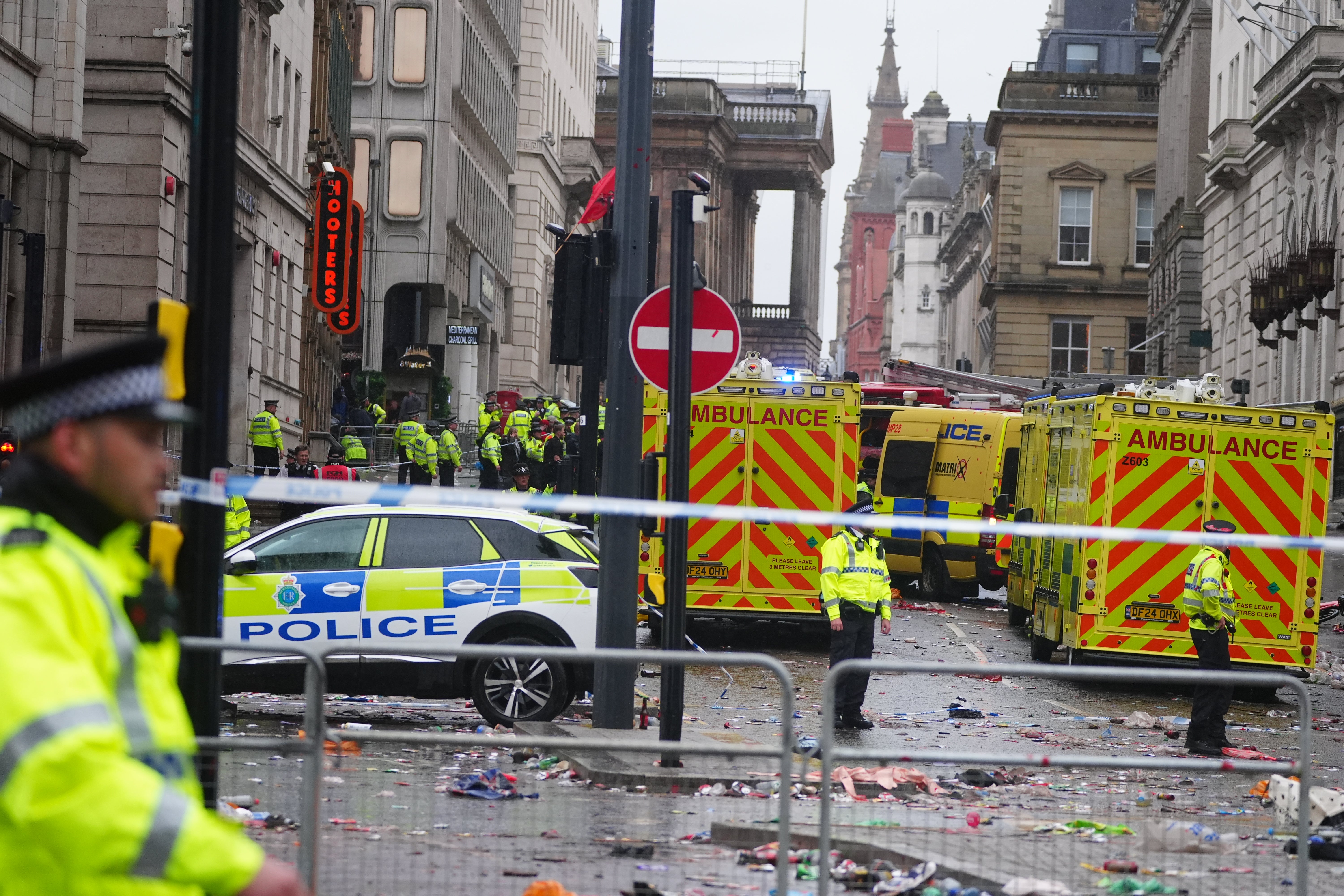 Policía y personal de emergencias atienden un incidente cerca del Liver Building, en Liverpool, durante el desfile de celebración por la victoria en la Premier League