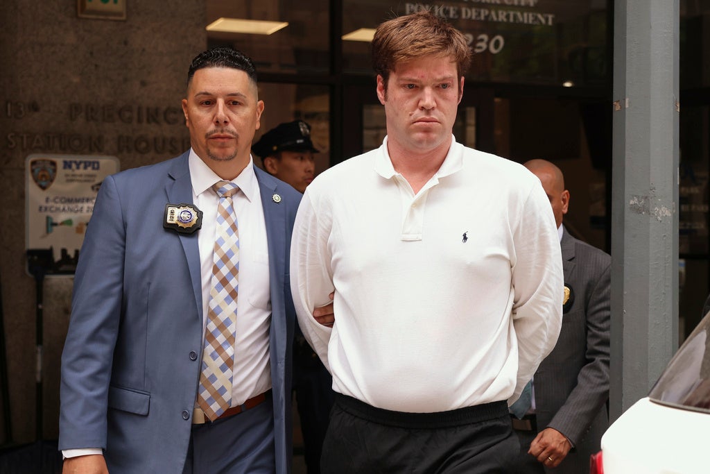 William Duplessie, a la derecha, es escoltado a la salida de la Comisaría 13 de la Policía de Nueva York tras entregarse frente a acusaciones de secuestro y detención ilegal, el martes 27 de mayo de 2025 en Nueva York