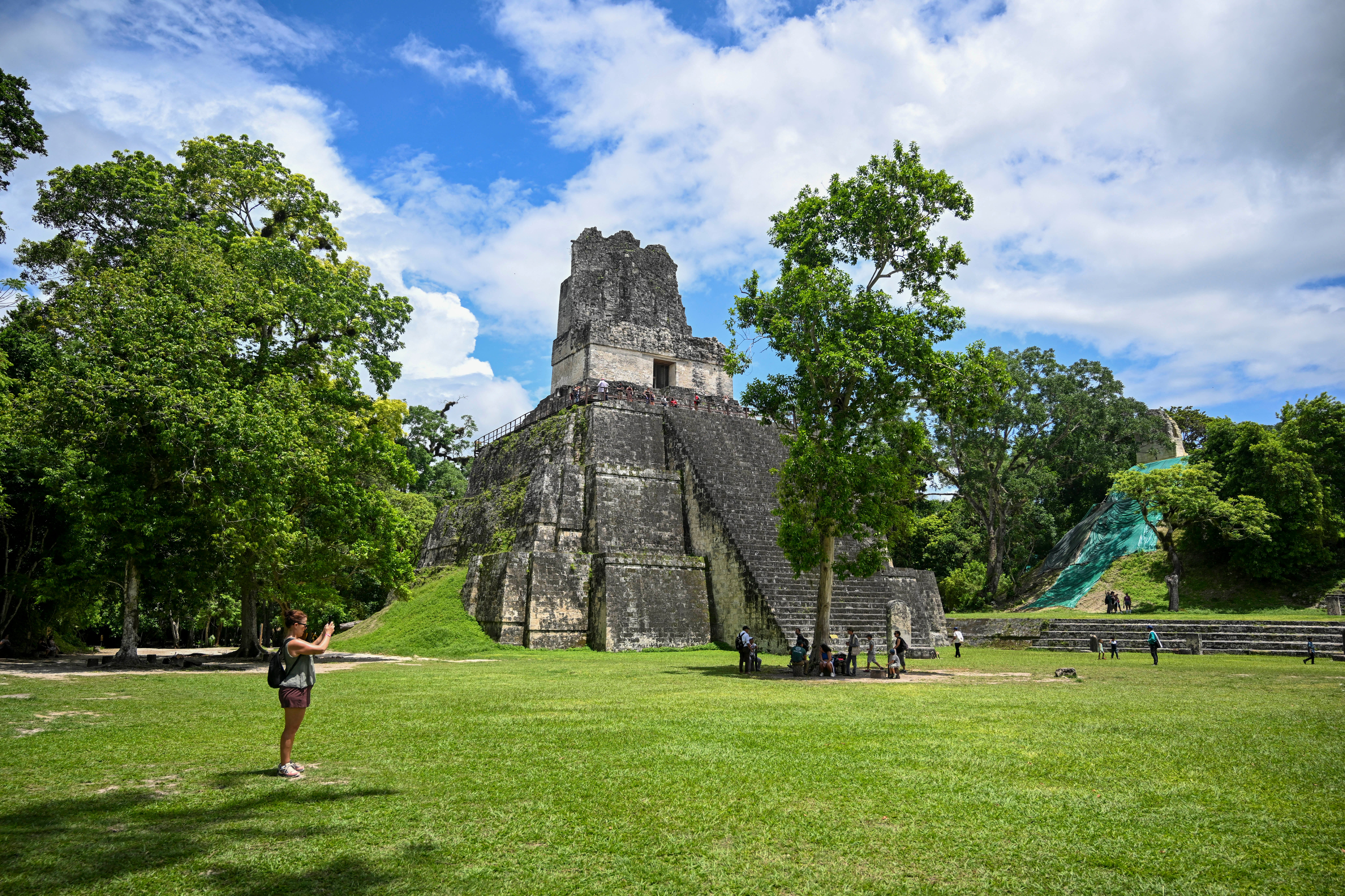 Un turista fotografía un templo maya en el sitio arqueológico de Tikal, ubicado en Petén
