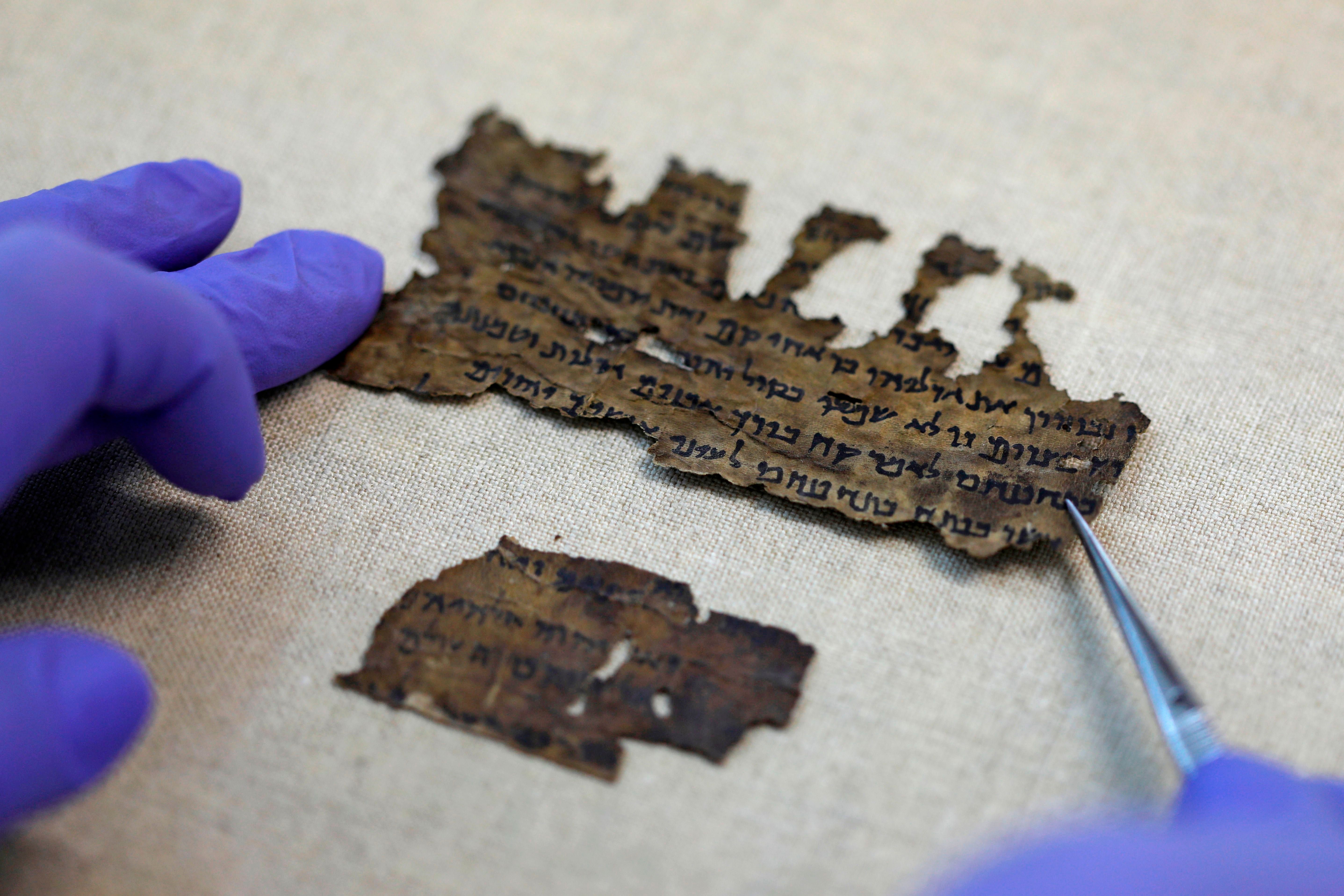 Un especialista de la Autoridad de Antigüedades de Israel examina fragmentos de los Manuscritos del Mar Muerto en su laboratorio