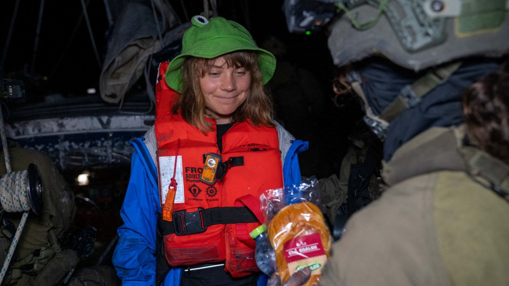 La activista climática Greta Thunberg, de 22 años, recibe alimentos de soldados israelíes a bordo del Madleen