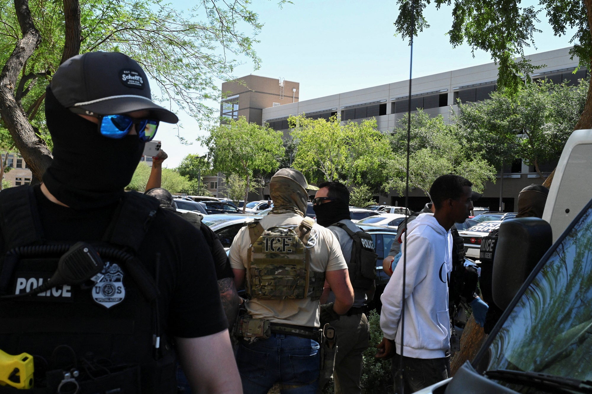 Autoridades policiales enmascarados —incluidos miembros del HSI e ICE— detienen a personas en un tribunal de inmigración en Phoenix, Arizona Los agentes usarían una aplicación para ubicar a inmigrantes y arrestarlos