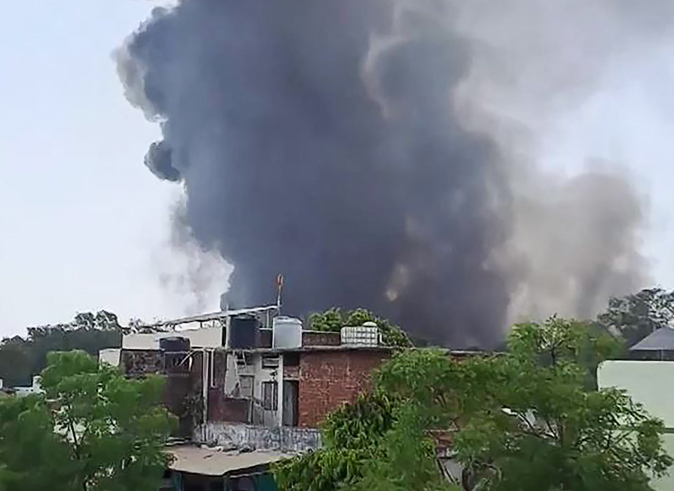 Una columna de humo se eleva después de que el vuelo 171 de Air India se estrellara cerca del aeropuerto de Ahmedabad