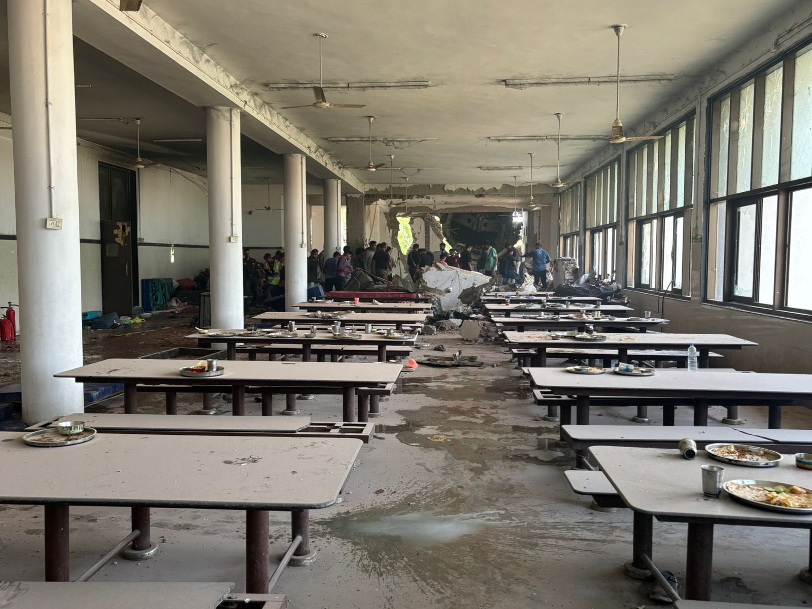 Platos de comida sin comer esparcidos en el comedor de un hostal de Ahmedabad después de que el vuelo AI-171 de Air India se estrellara contra el edificio el jueves por la tarde