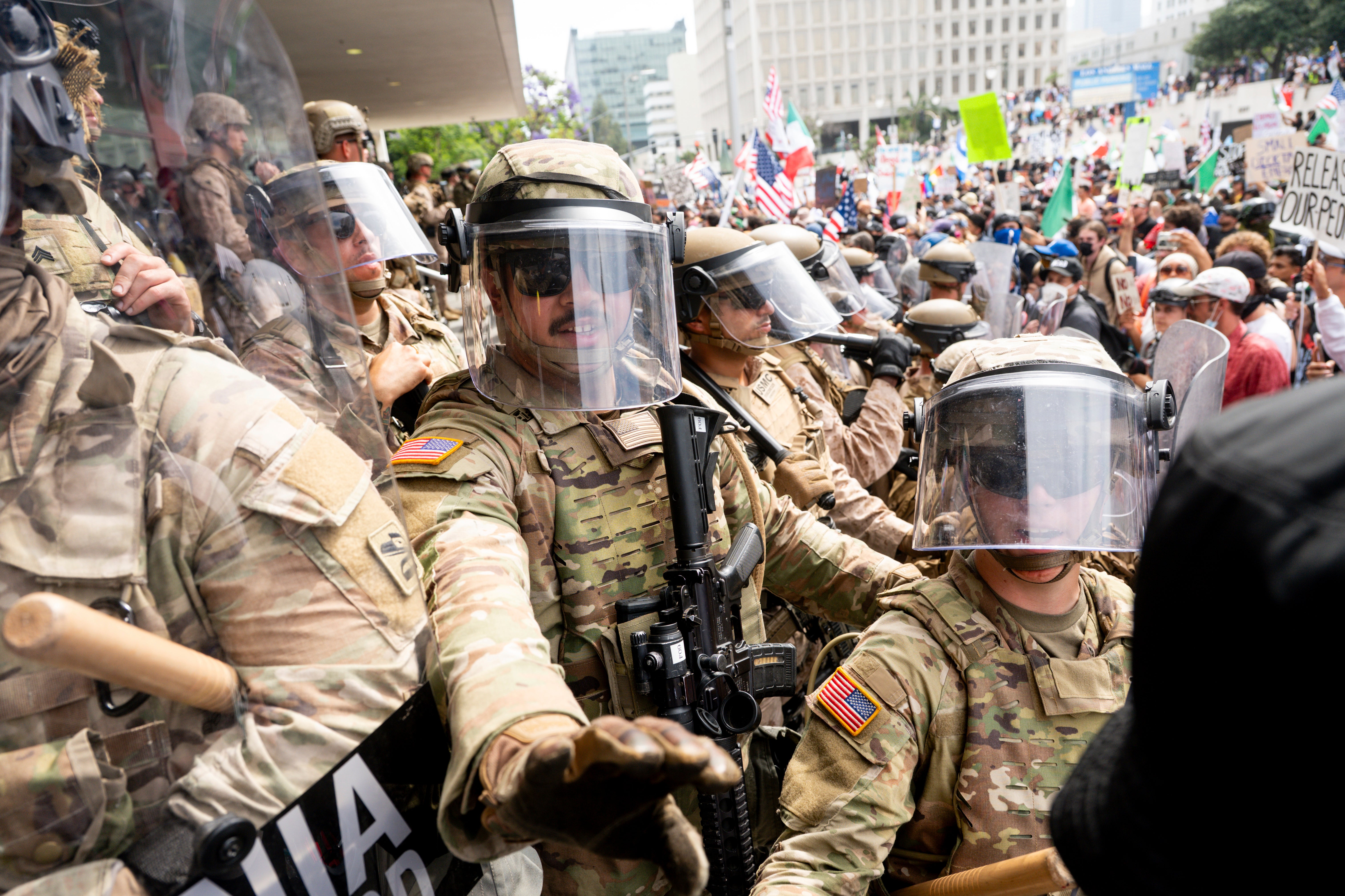 La Guardia Nacional de California e infantes de marina retienen a los manifestantes en el Edificio Federal durante una protesta el sábado en Los Ángeles