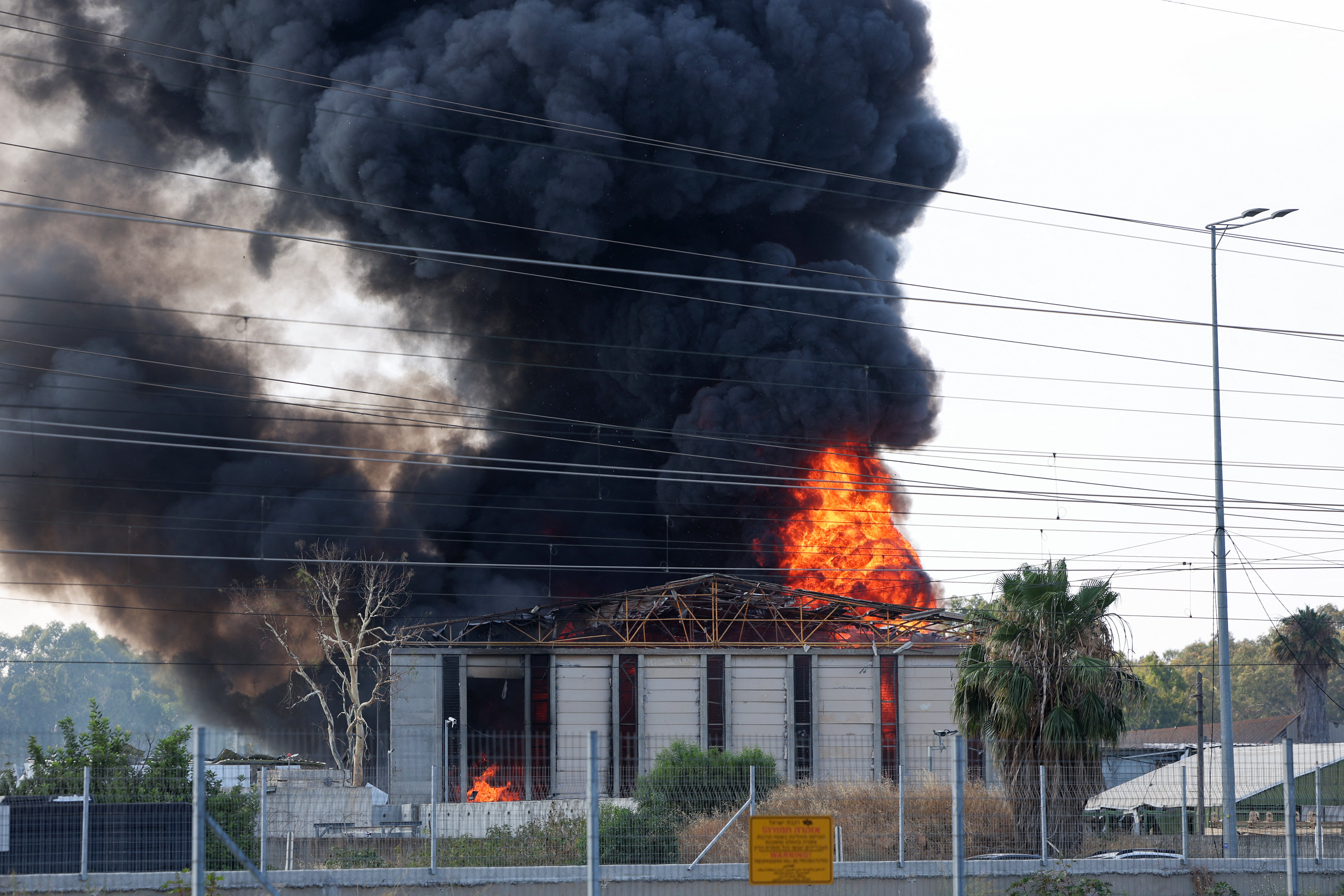 El humo sale de un incendio en un edificio de Herzliya, cerca de Tel Aviv, tras una nueva descarga de cohetes iraníes el martes