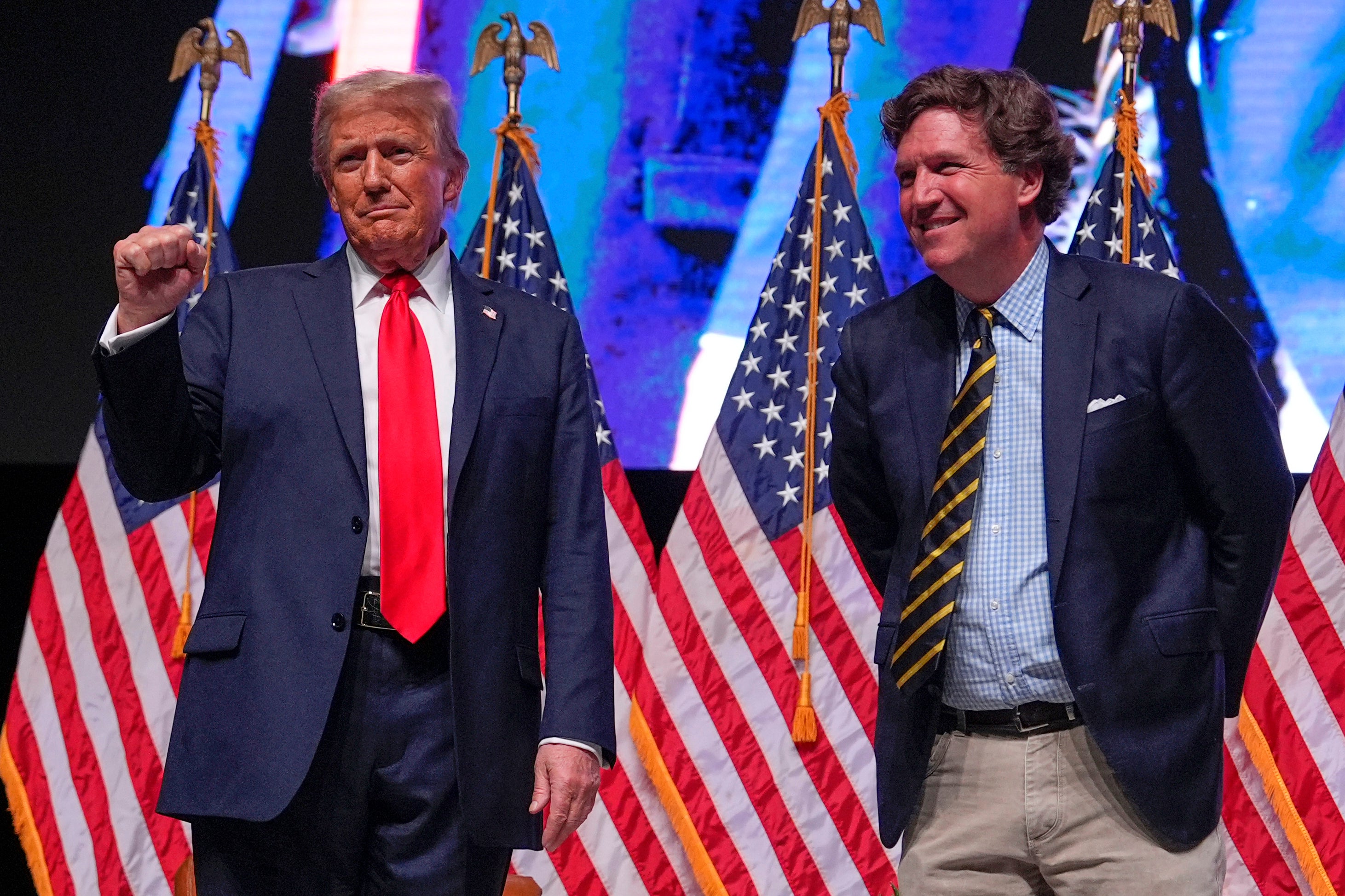 Tucker Carlson hace campaña junto a Donald Trump sobre el escenario en Glendale, Arizona, en los últimos días de la elección presidencial de 2024