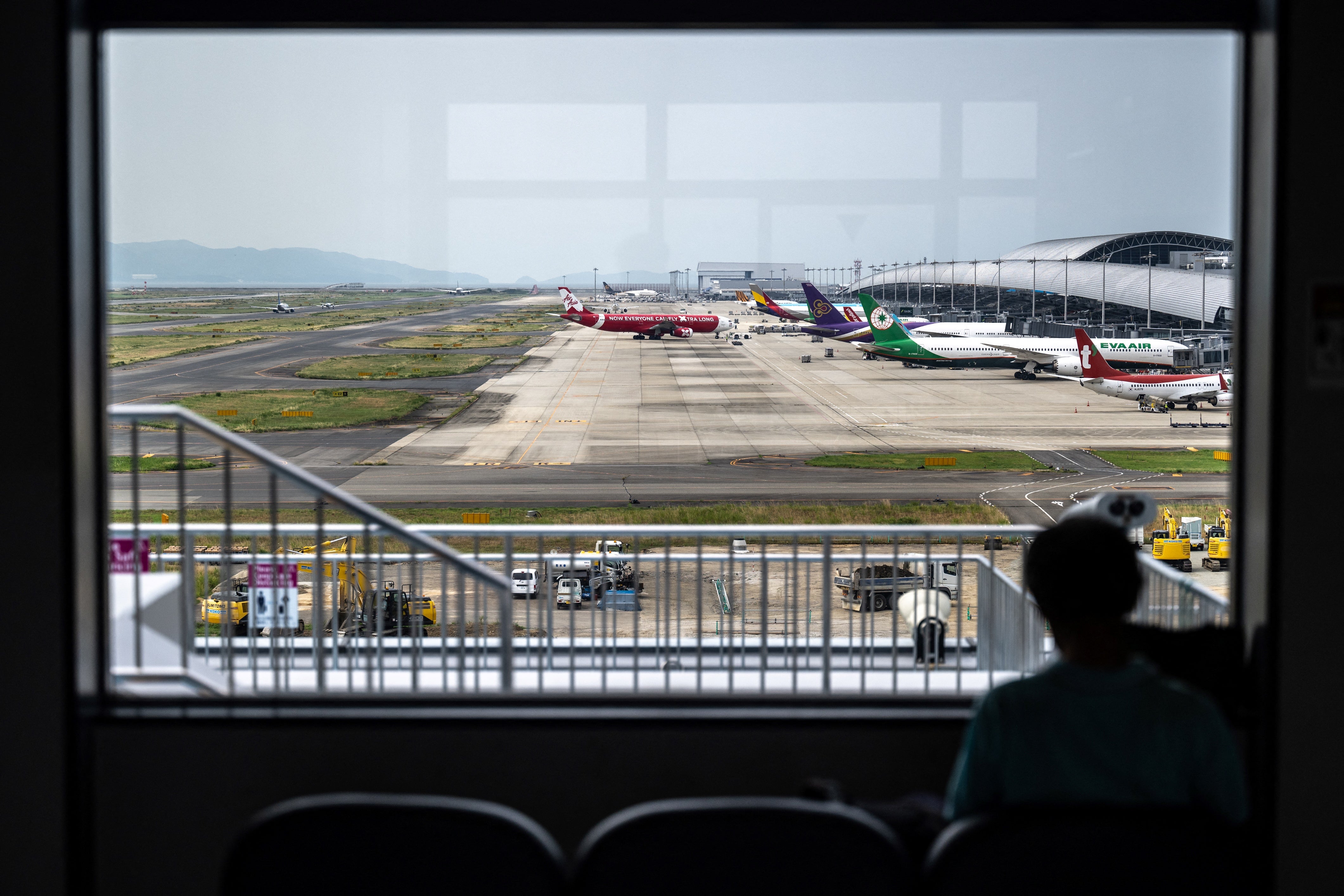 Persona mirando aviones en el aeropuerto internacional de Kansai de la prefectura de Osaka, Japón