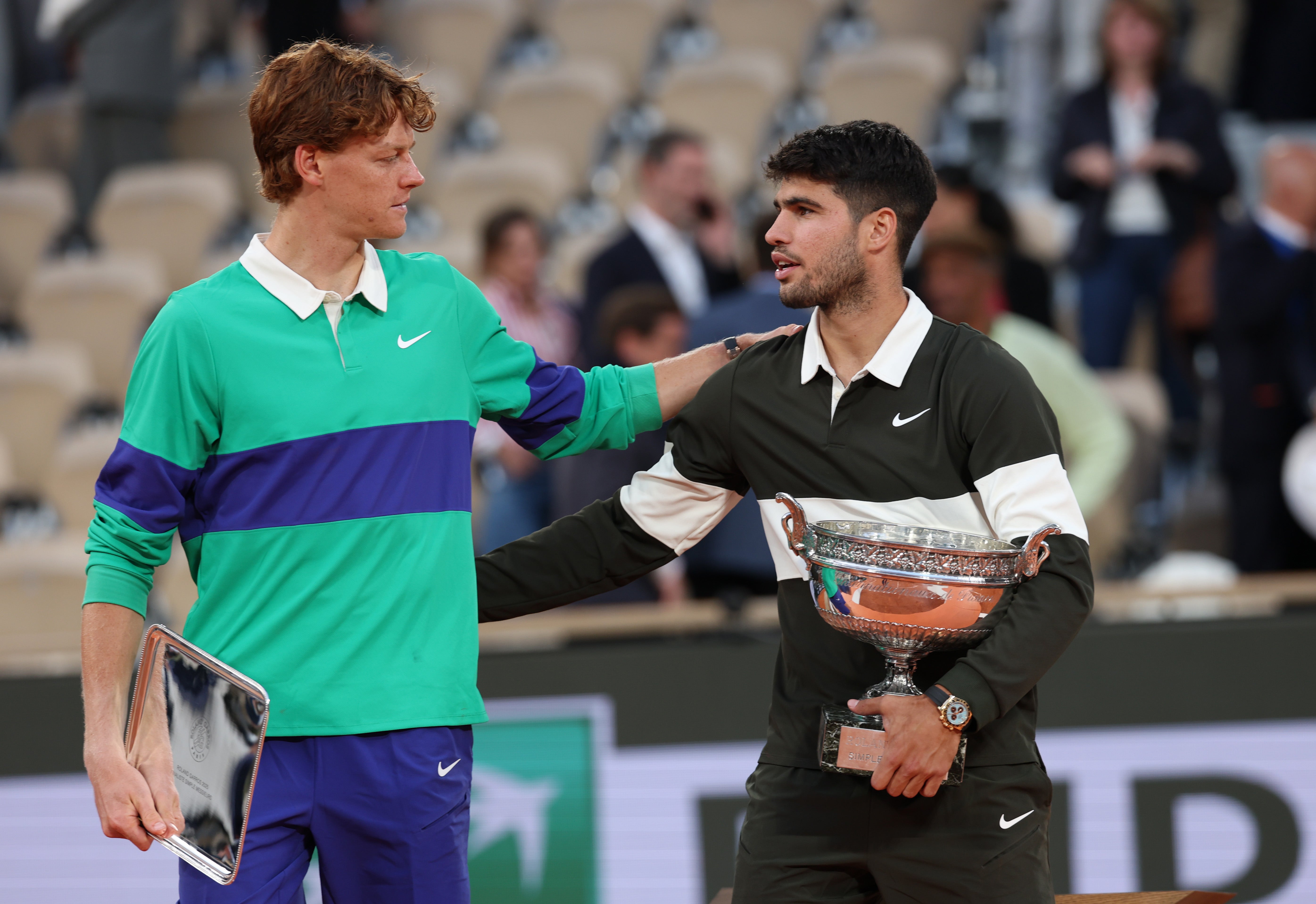 Carlos Alcaraz, a la derecha, sostiene el trofeo de la Coupe des Mousquetaires en Roland Garros mientras conversa con el subcampeón Jannik Sinner