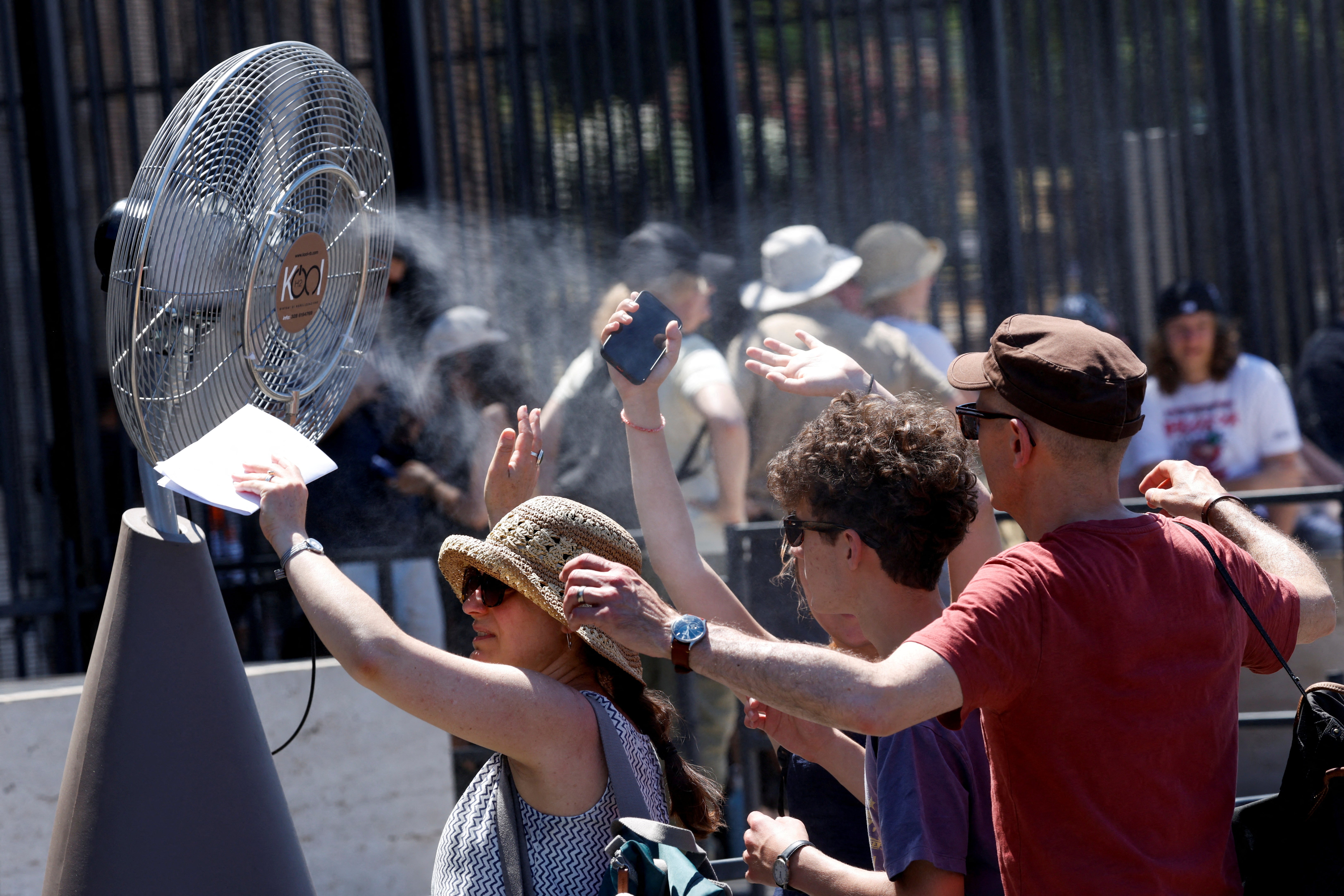 Turistas ante un ventilador instalado en el exterior del Coliseo de Roma el lunes