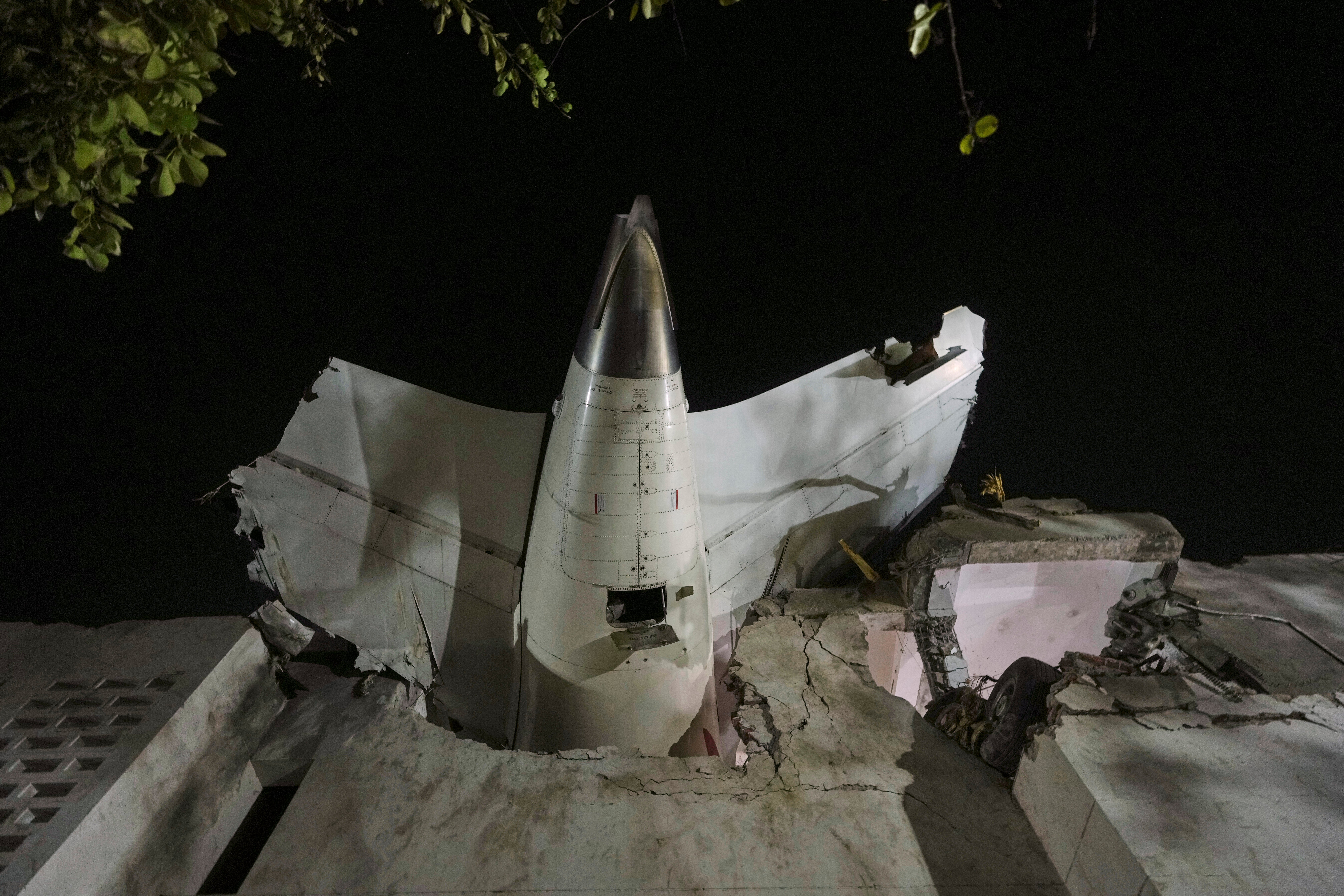 La cola del avión se ve atascada en un edificio en el lugar del accidente en la ciudad noroccidental india de Ahmedabad, en el estado de Gujarat, el jueves 12 de junio de 2025