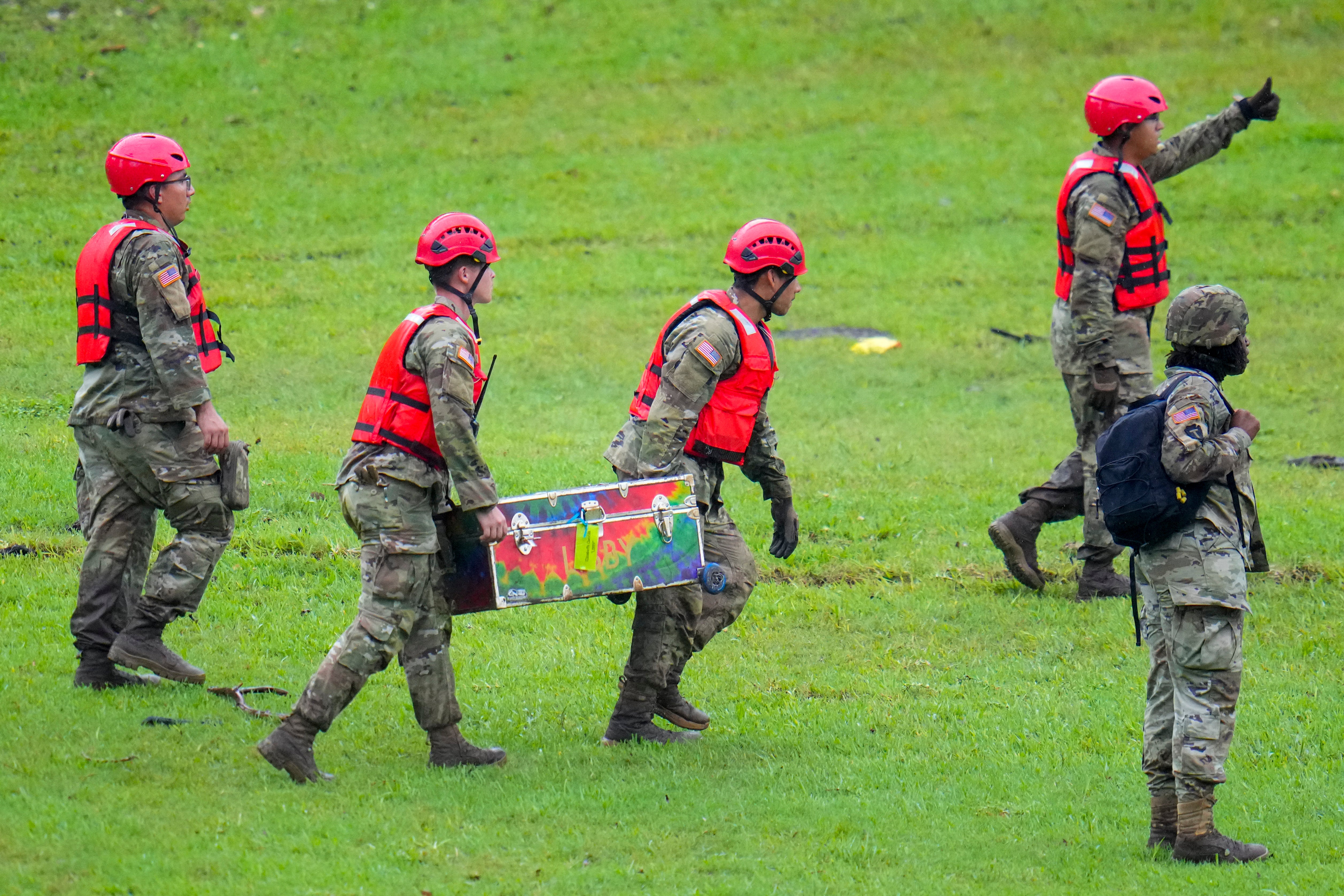 La búsqueda de personas desaparecidas entra en su cuarto día, luego de que las autoridades confirmaran un total de 82 muertes provocadas por las inundaciones. Personal militar trasladó un baúl de campamento que fue recuperado río abajo del campamento.