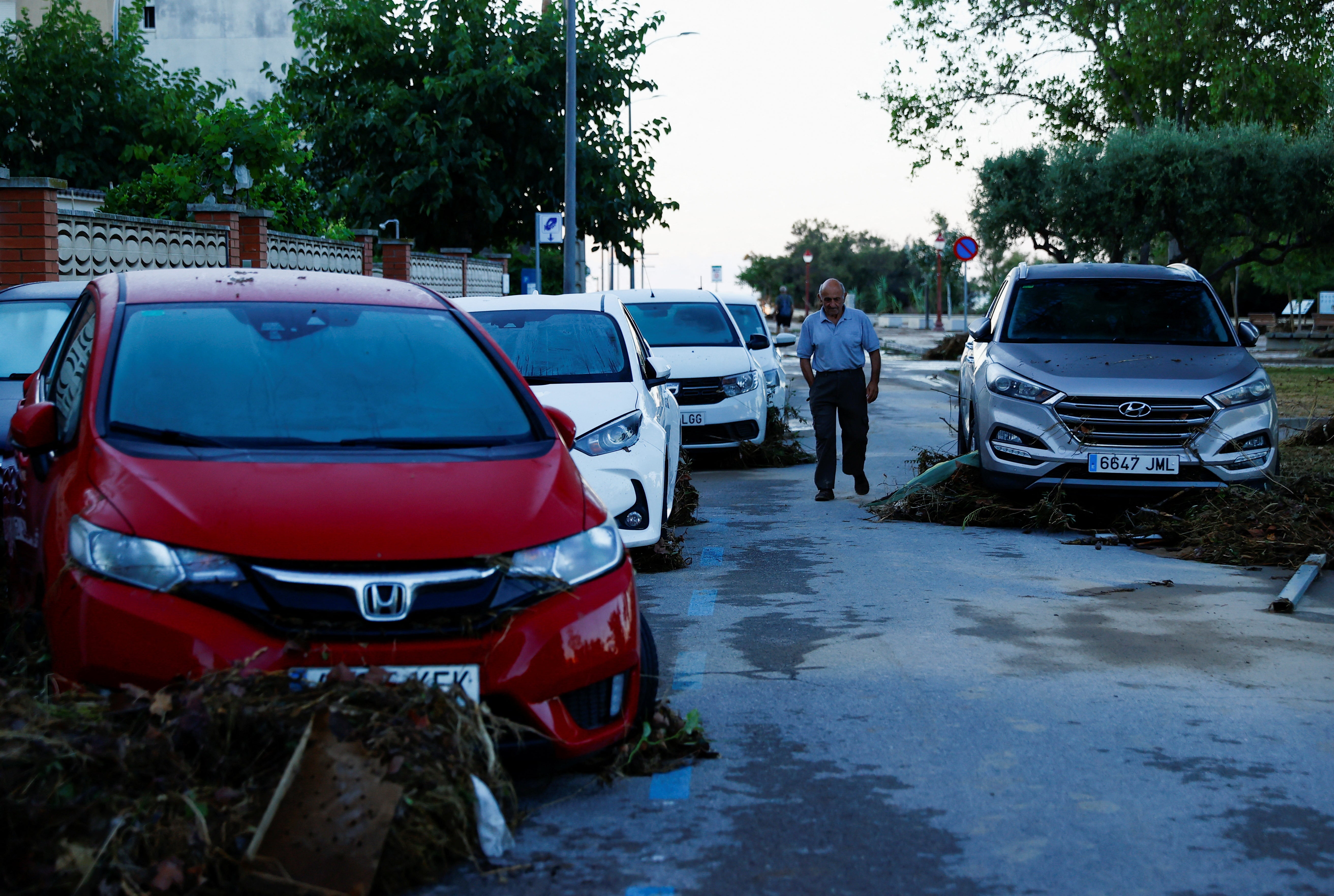 Un hombre camina junto a coches dañados en Cubelles tras las inundaciones repentinas del fin de semana
