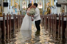 AP Fotos: Pareja filipina camina por un pasillo inundado el día de su boda