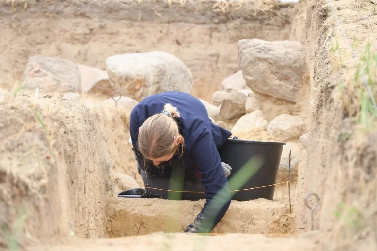 Arqueólogos excavan cuidadosamente la estructura de piedra de la tumba