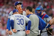 Ohtani deja el montículo acompañado por un entrenador tras lanzar seis bolas