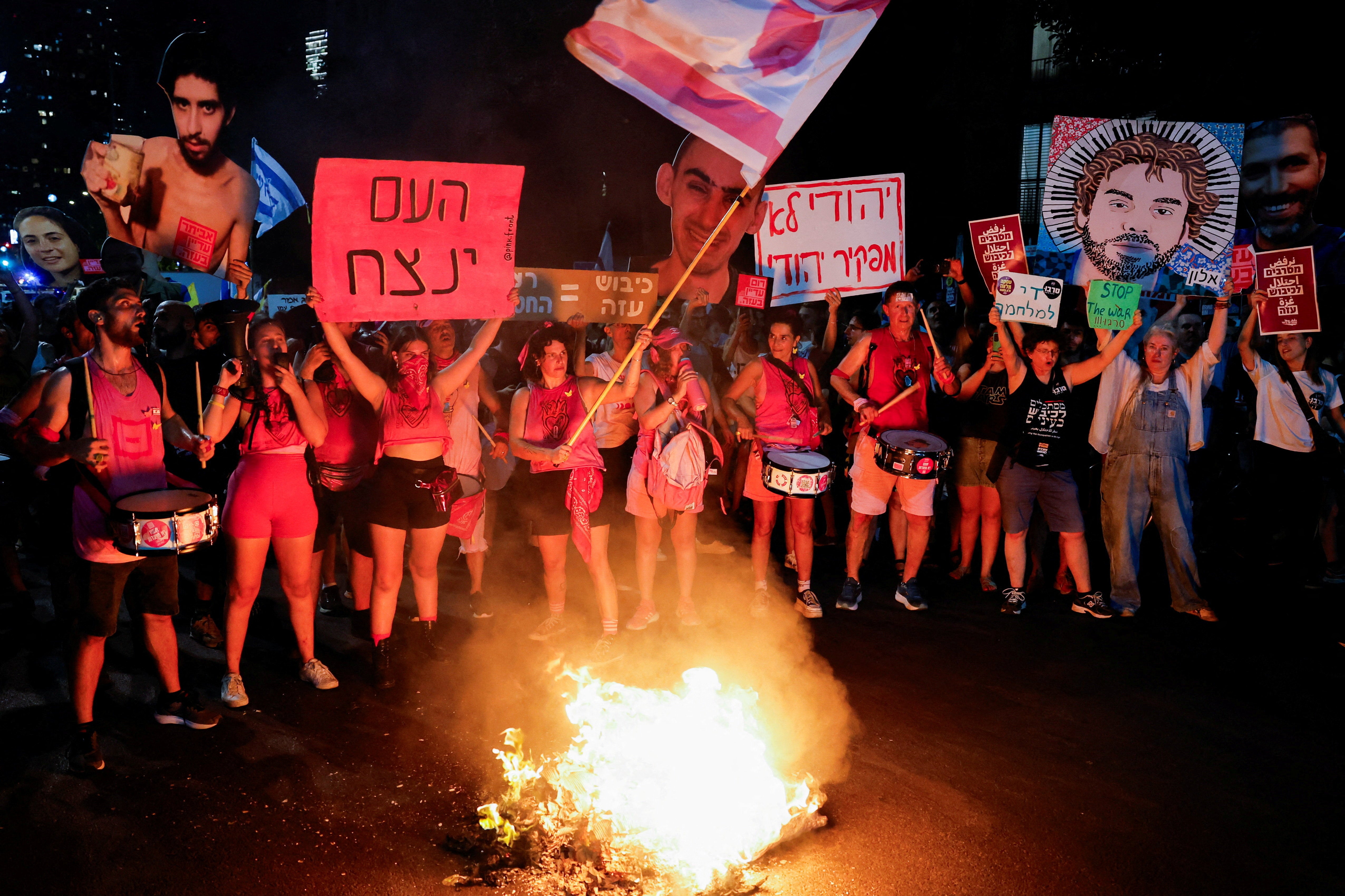 Manifestantes y familiares de los rehenes secuestrados durante el mortífero ataque del 7 de octubre de 2023 contra Israel por parte de Hamás protestan exigiendo la liberación inmediata de los rehenes y el fin de la guerra, mientras arde un fuego en Tel Aviv, Israel, 7 de agosto de 2025