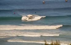 Barco de pasajeros tipo yate encalla en fuerte oleaje frente a playa de Hawai