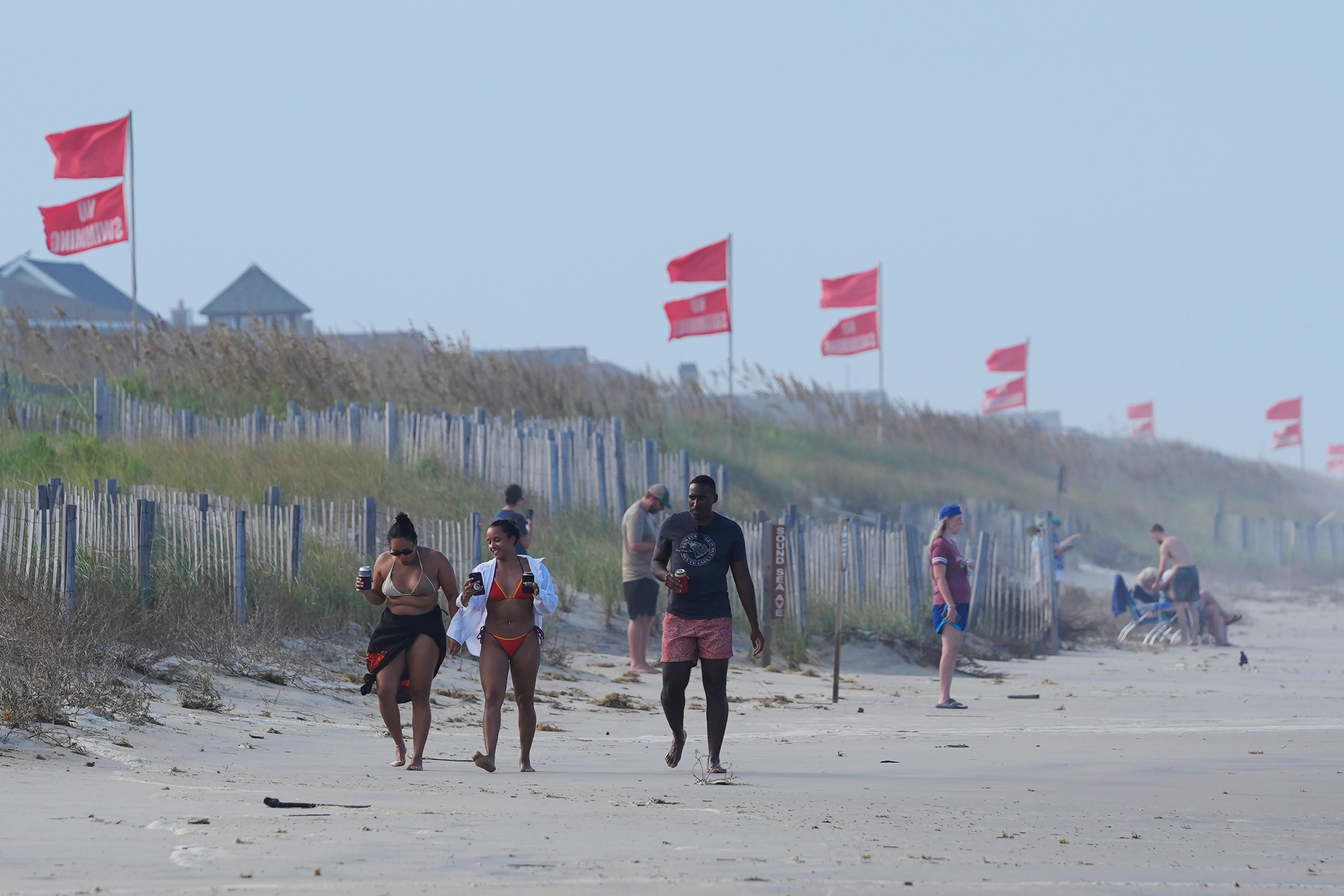 Banderas rojas ondean en la playa de Duck, Carolina del Norte, tras el repentino cambio de trayectoria del huracán Erin, cuyos vientos de categoría 2 obligaron al cierre de playas y a declarar el estado de emergencia en el estado. (AP)