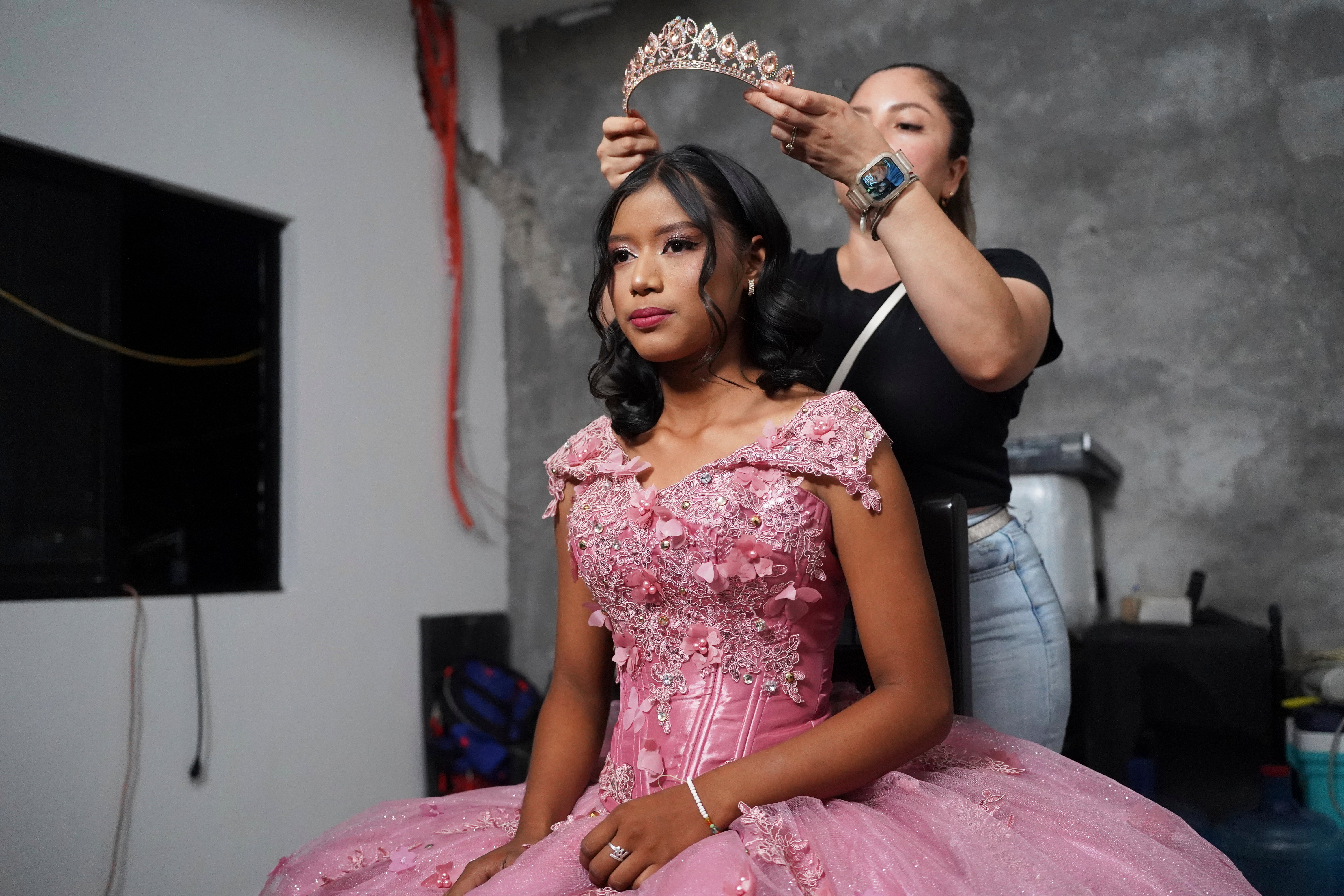 Una estilista prepara a Isela Santiago Morales para su fiesta de 15 años, organizada por la comunidad después de que el llamamiento de su padre en las redes sociales atrajera apoyo tras su primera celebración poco concurrida, en Axtla de Terrazas, México, el sábado 23 de agosto de 2025