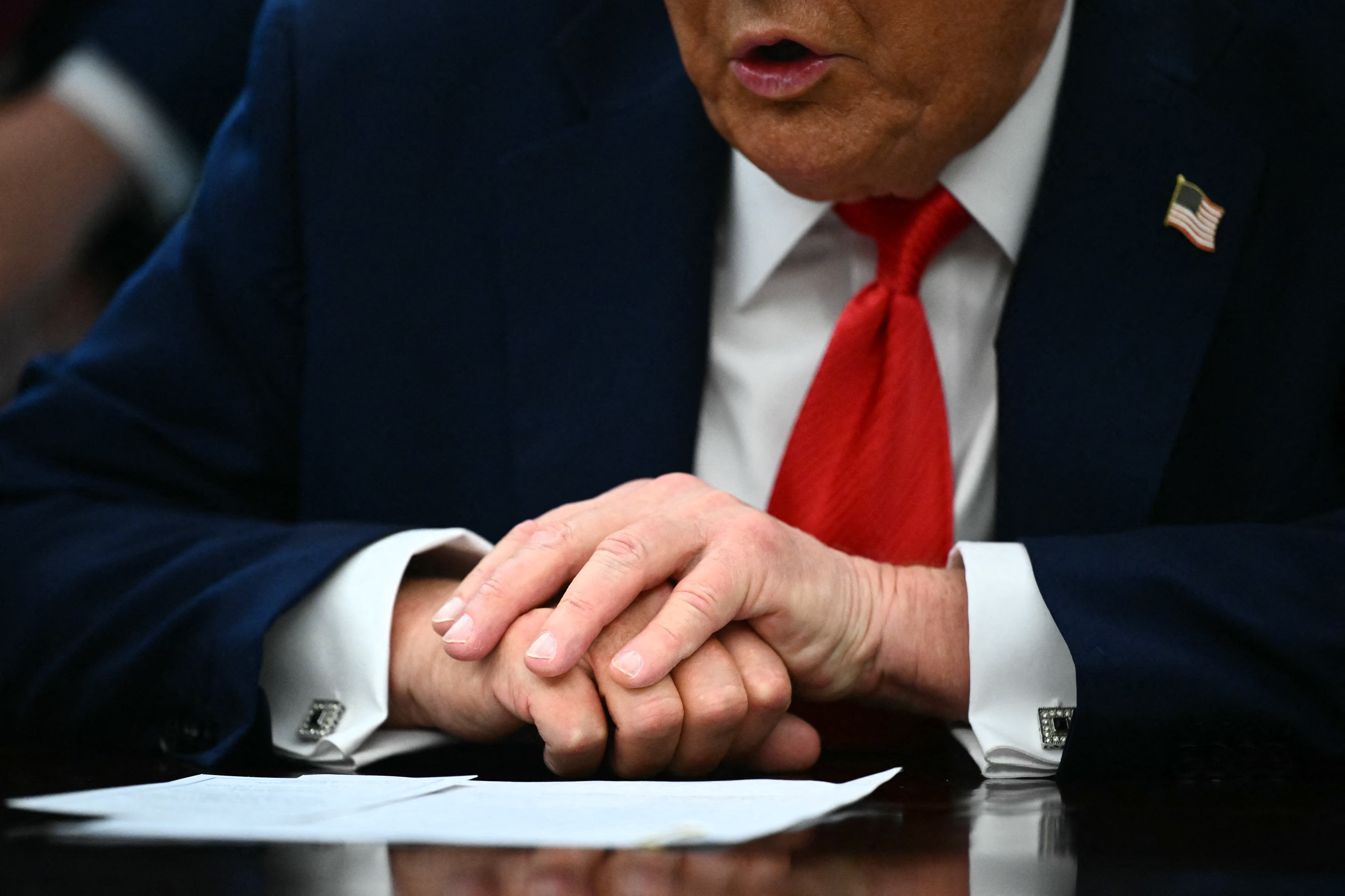 Trump mantuvo su mano izquierda sobre su mano derecha mientras hablaba con los periodistas en la Oficina Oval el lunes —más tarde, sin embargo, se pudo ver un moretón en el dorso de su mano derecha