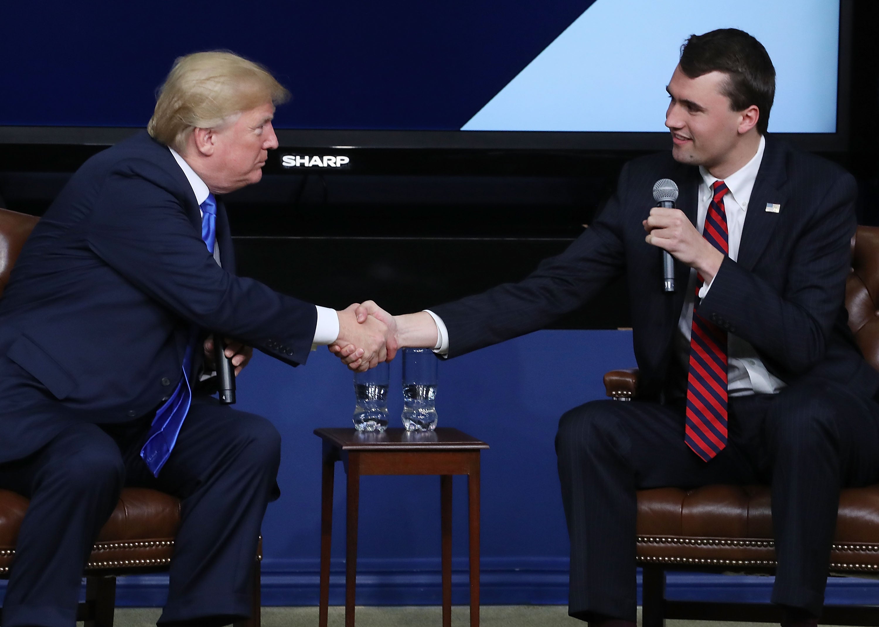 Charlie Kirk estrecha la mano del presidente Donald Trump en un evento de Turning Point USA en marzo de 2018