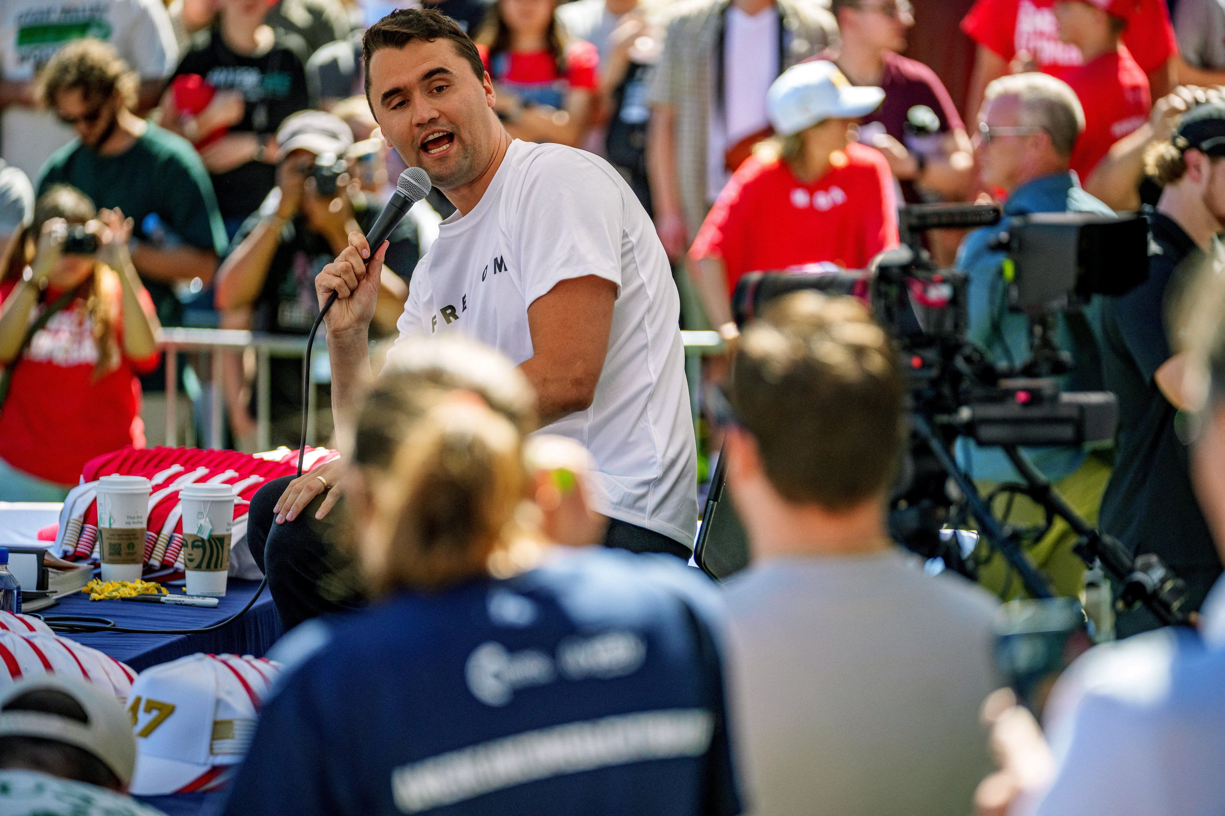 Charlie Kirk reparte artículos promocionales durante su discurso del miércoles en la Universidad del Valle de Utah, en Orem