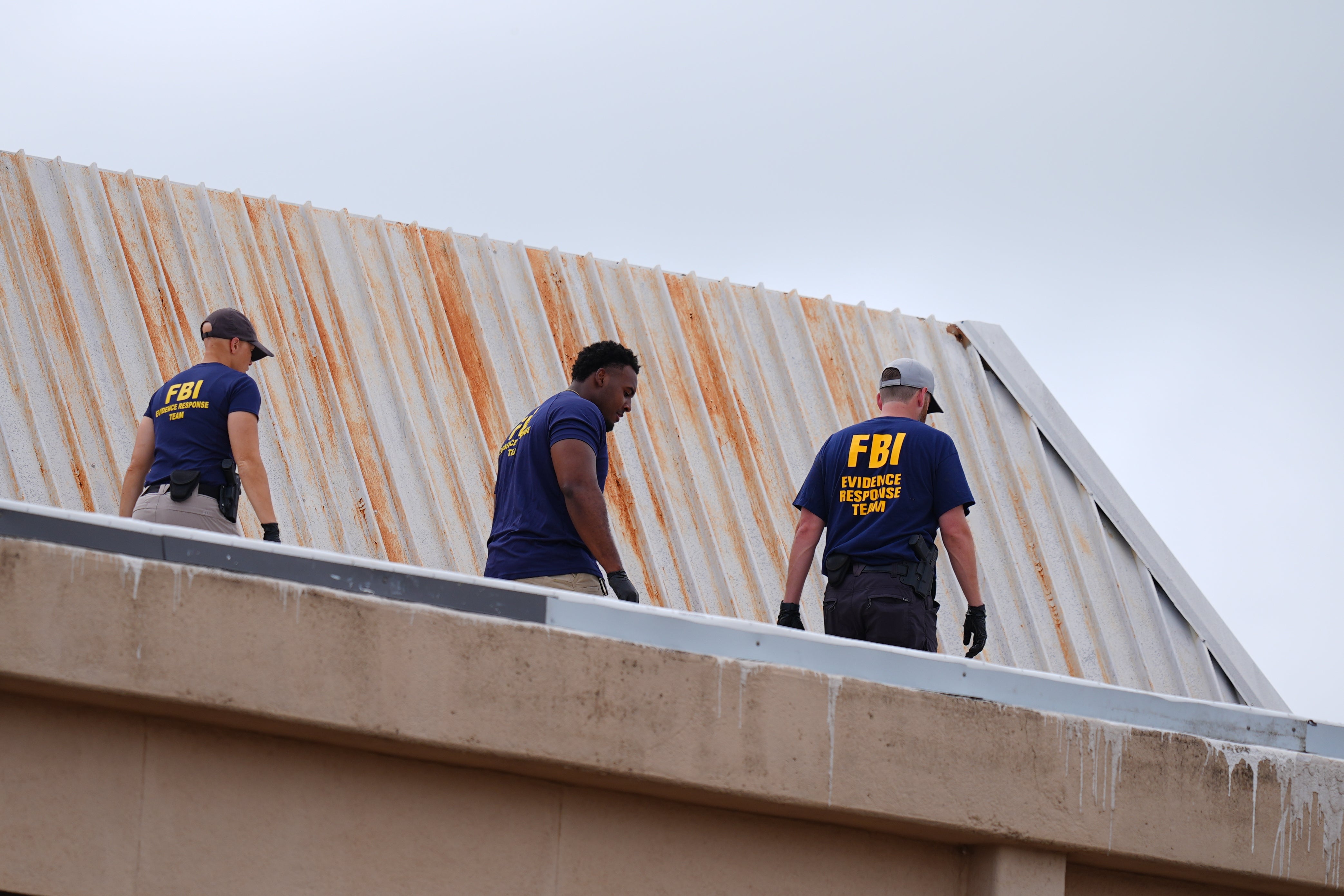 Agentes del FBI inspeccionan el tejado de un edificio de apartamentos cercano al lugar del tiroteo