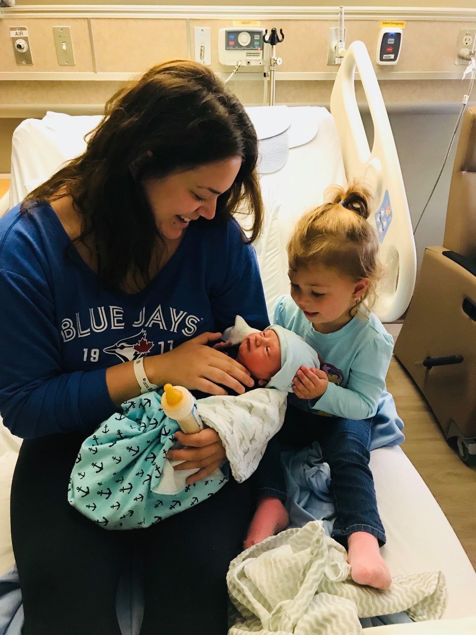 Ariel Taylor presenta a su hija biológica a uno de los bebés que gestó para otra pareja, poco después de su nacimiento. Taylor describe la experiencia como algo especial, aunque muy diferente de llevar en el vientre a su propia hija